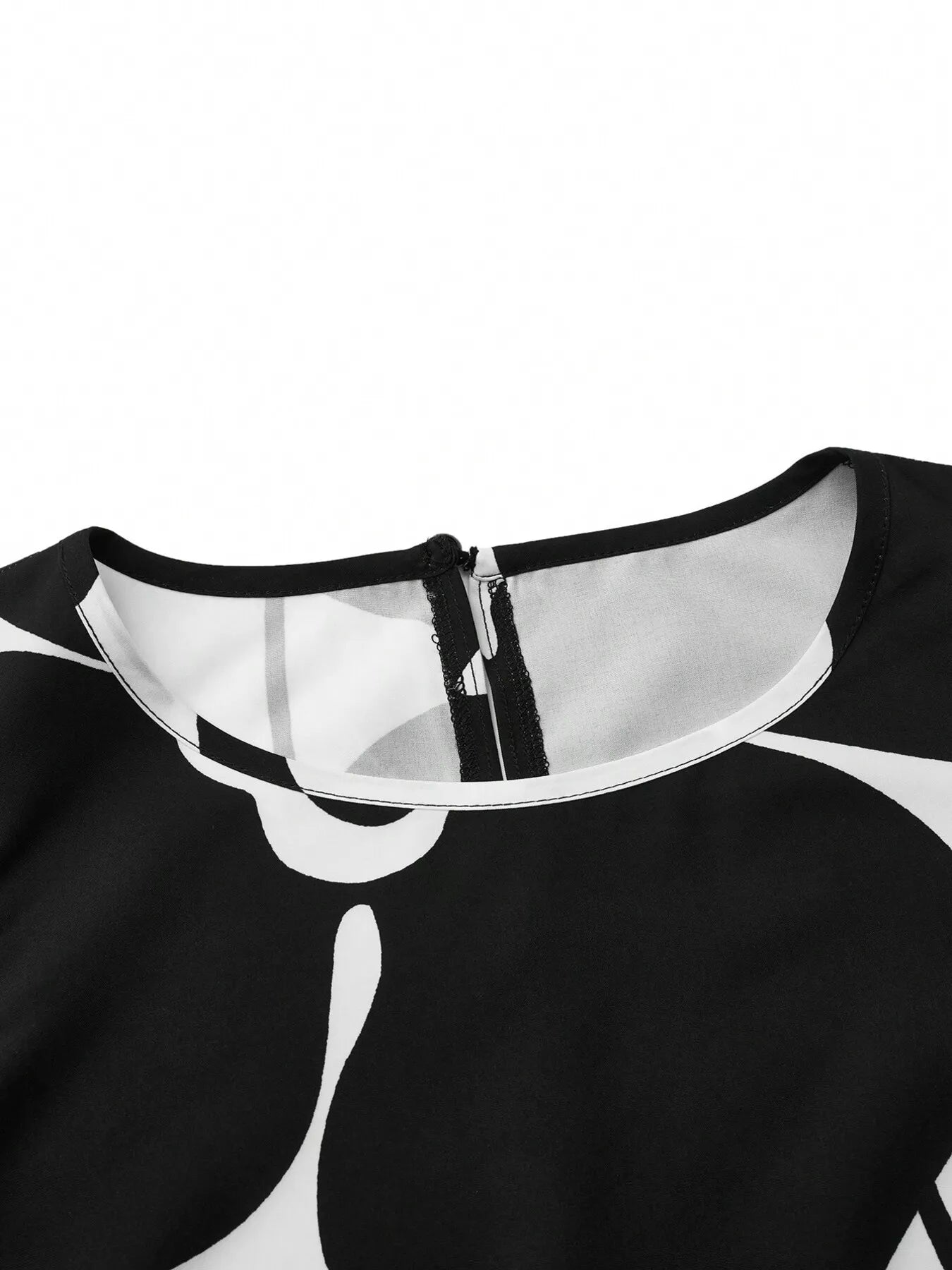 Sleeveless dress neckline close-up with black-and-white floral print and zipper