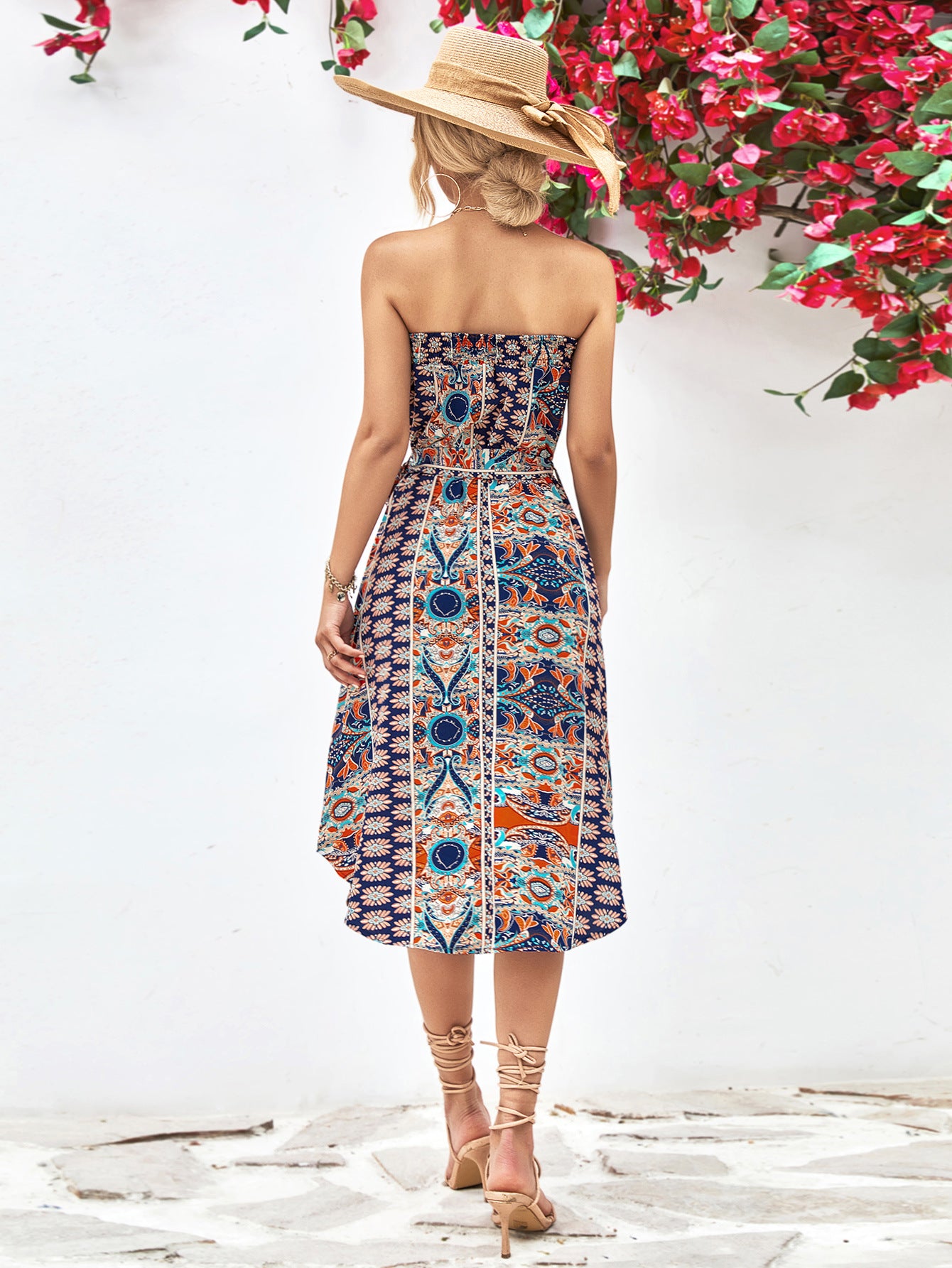 Back view of printed strapless tie belt dress, blue multicolor medallion pattern, midi length