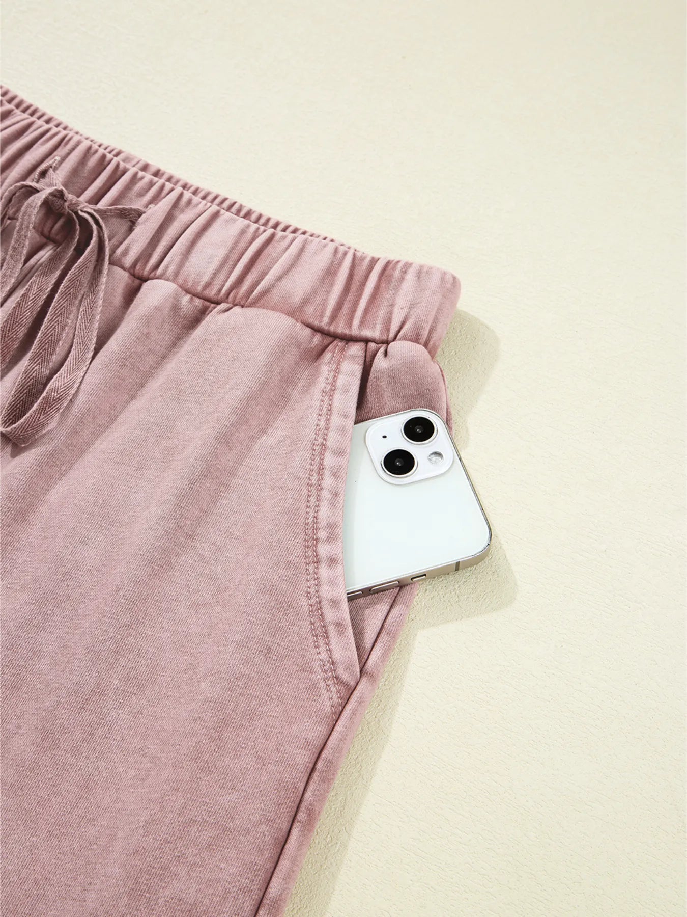 Dusty pink wide-leg pants with drawstring waist and side pocket seam detail