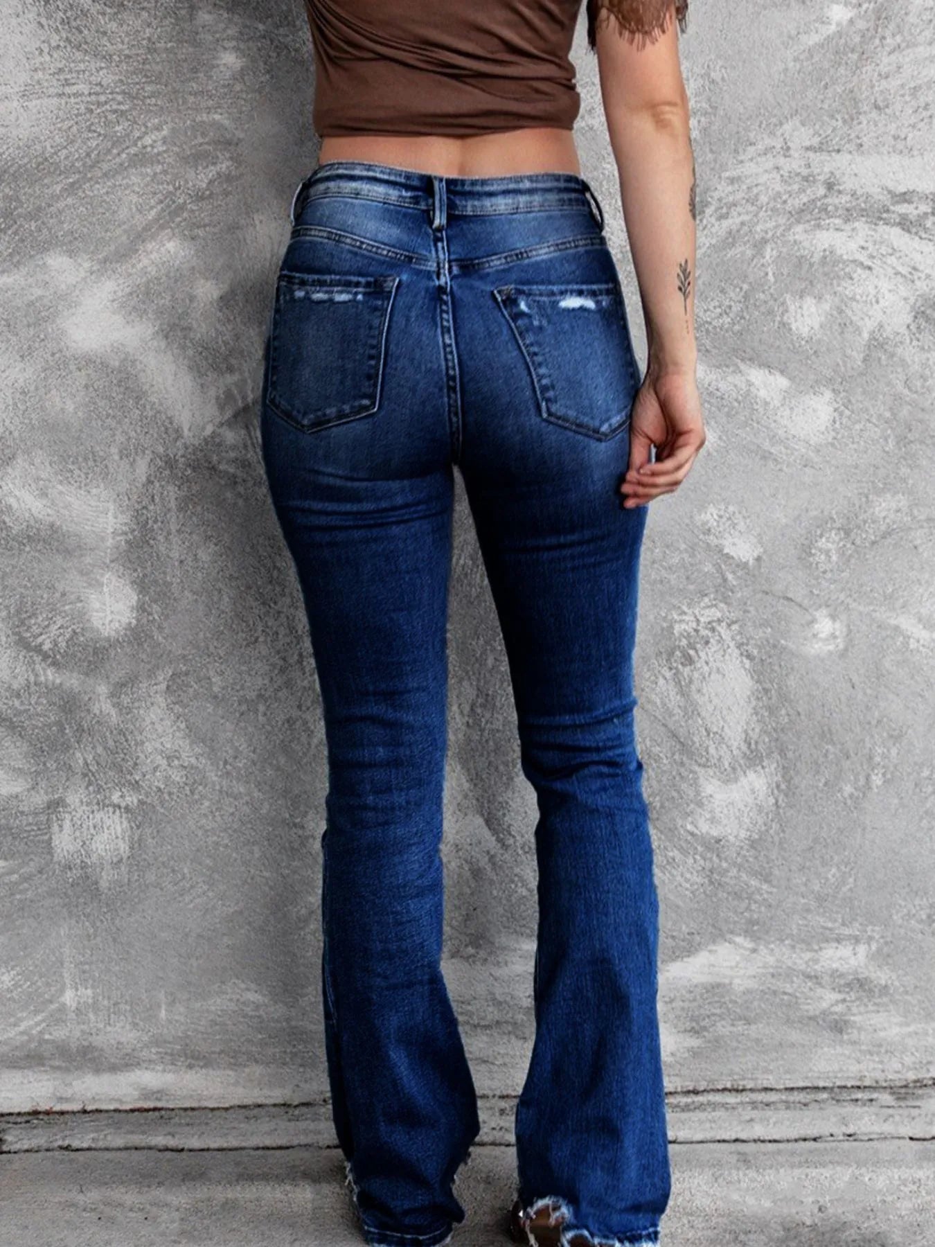 Medium blue distressed flare jeans with front whiskers and faded wash on the thighs