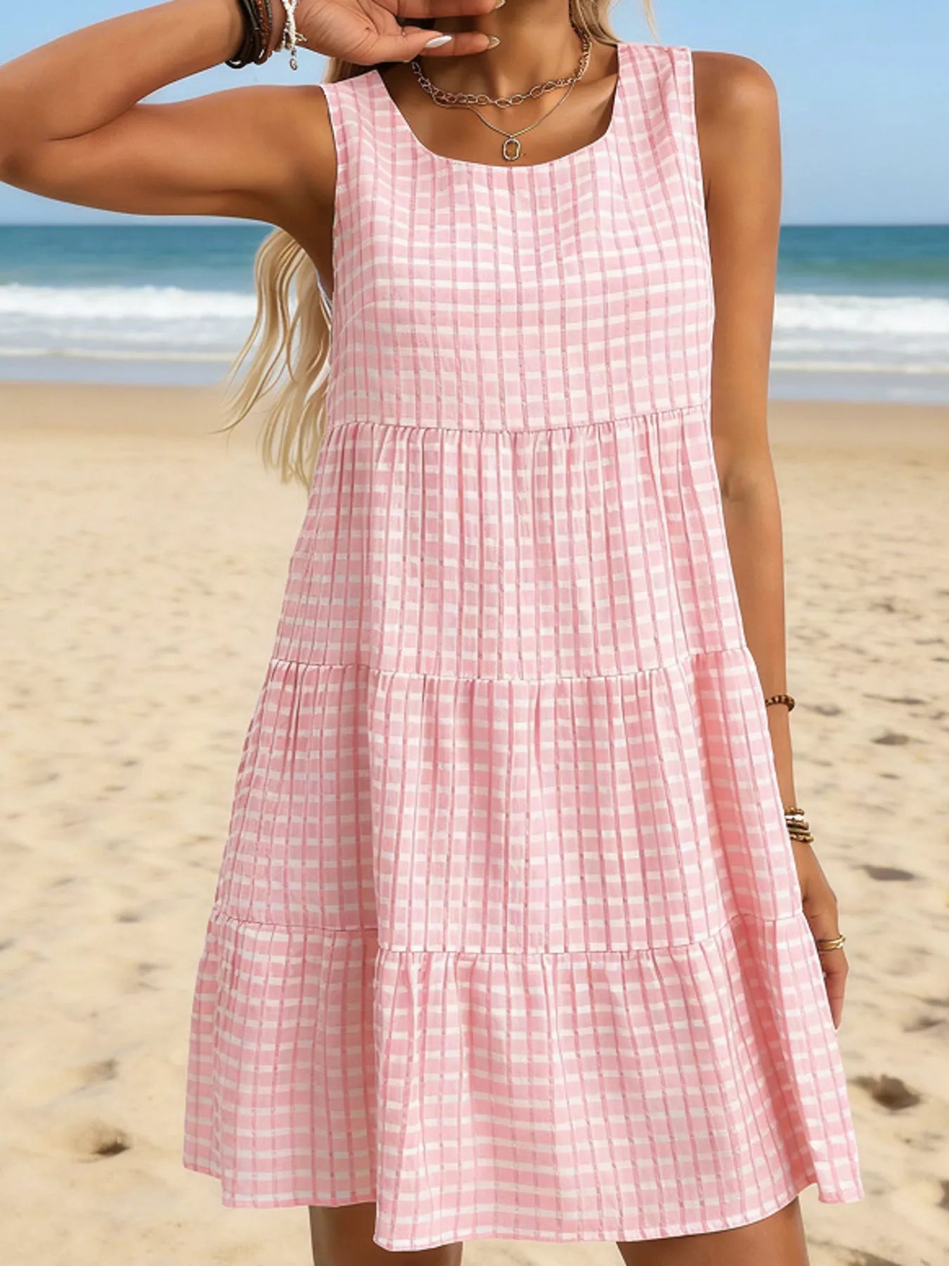 Pink check-pattern sleeveless tiered mini dress with round neckline and gathered tiers
