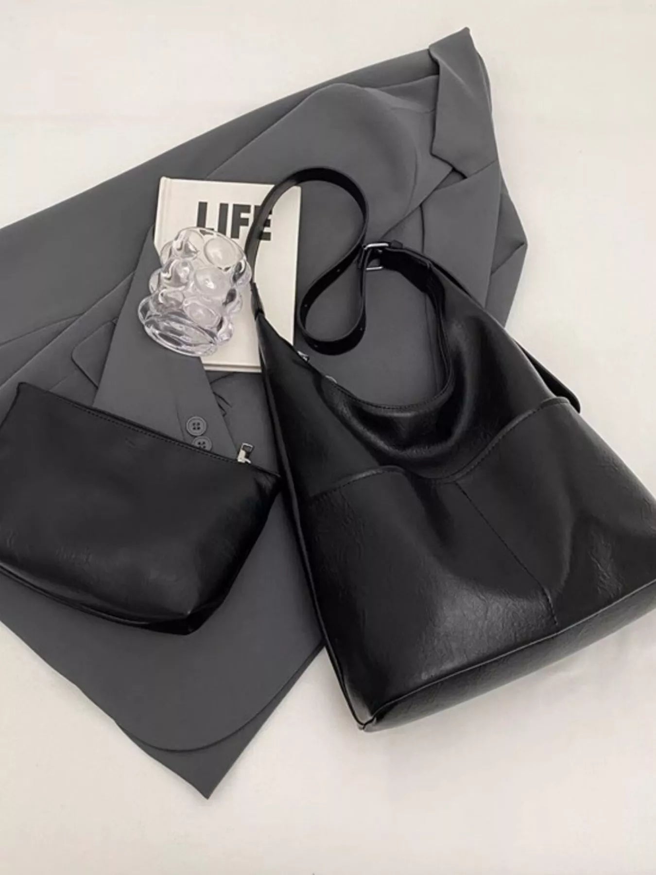 Black hobo-style shoulder bag with adjustable strap and open top