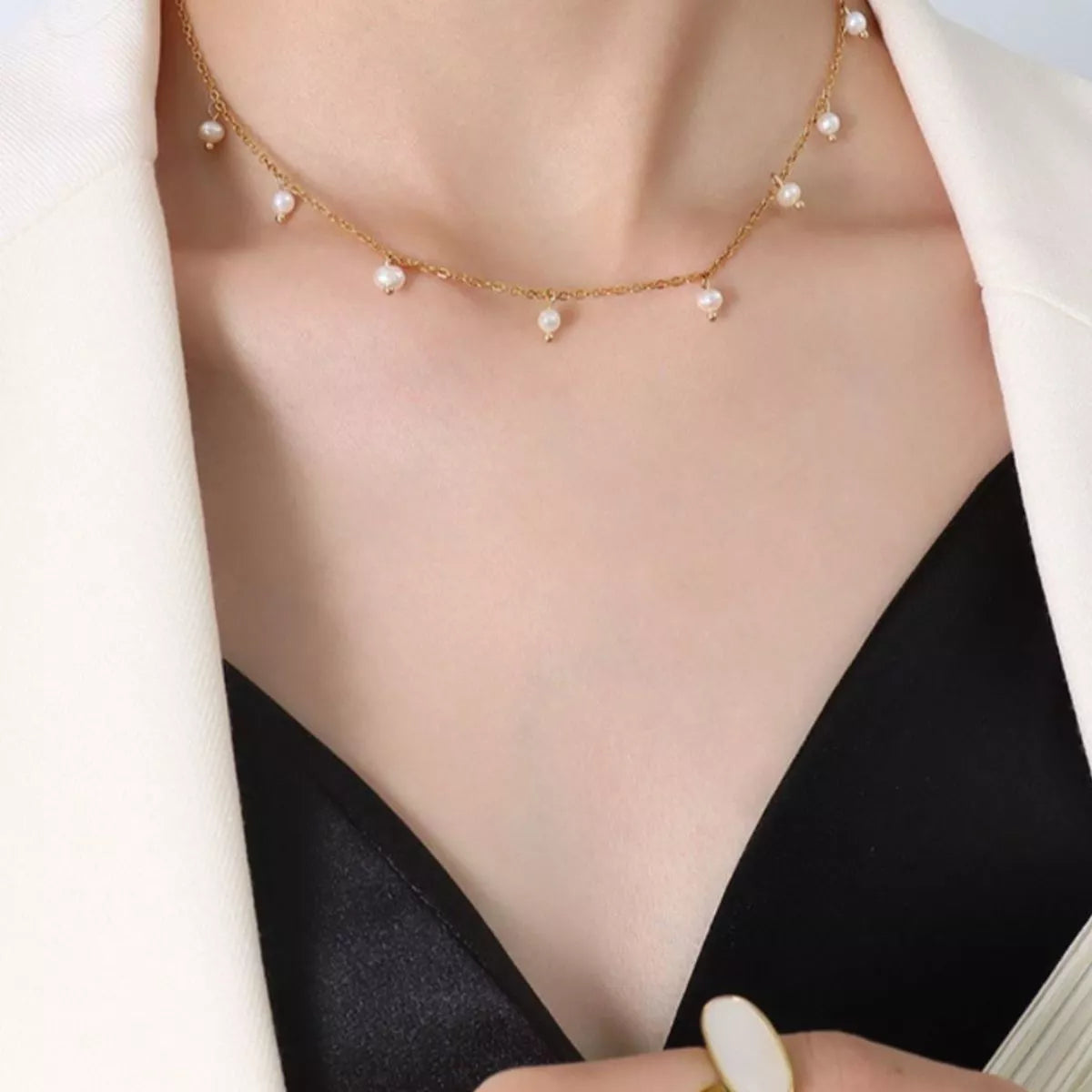 Gold-plated freshwater pearl necklace resting on a V-neck collarbone