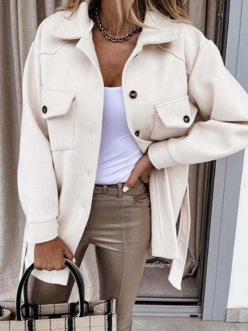 White button-down tie-waist coat with shoulder epaulets, flap pockets, and dark buttons