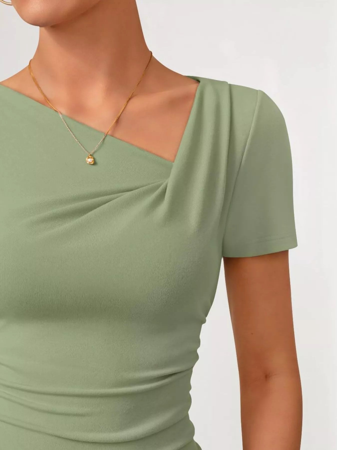 Cedar & Moore Asymmetrical Neckline Fitted T‑Shirt in sage green with a gold pendant necklace