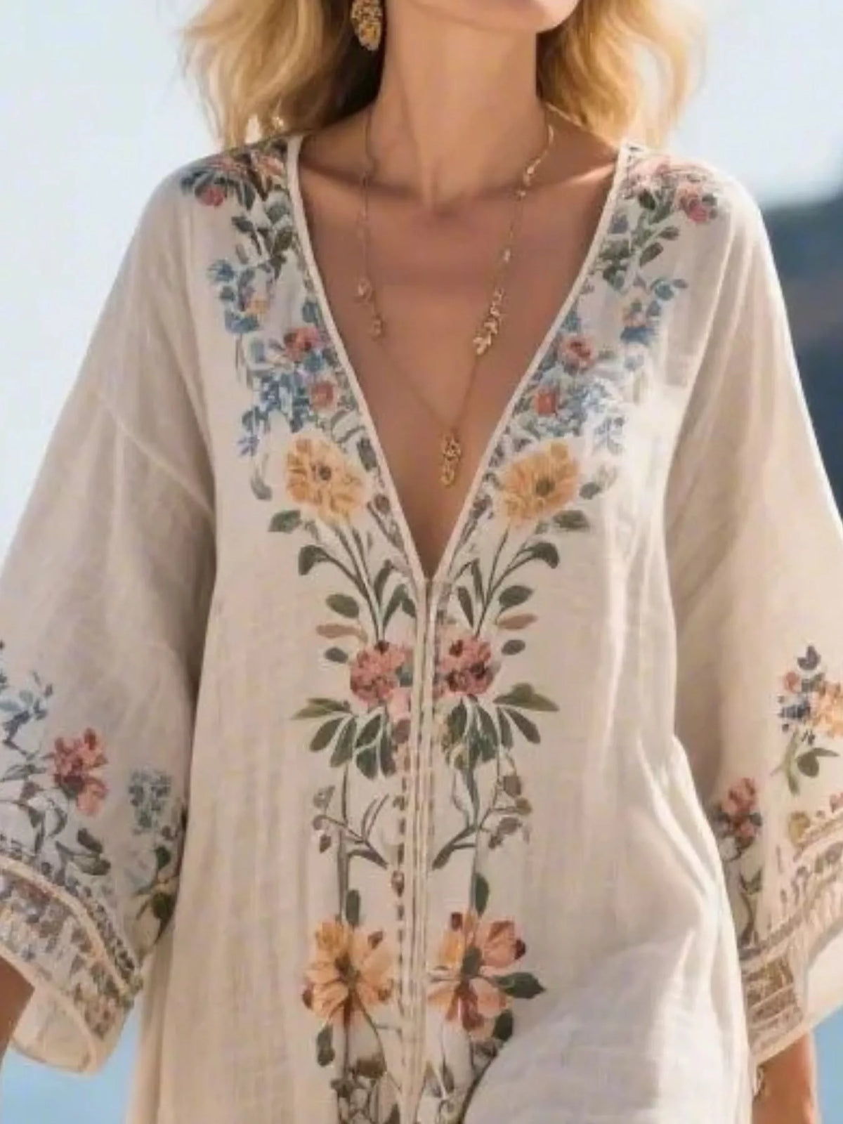 Floral V-neck maxi dress detail with embroidered bouquet print and tassel trim