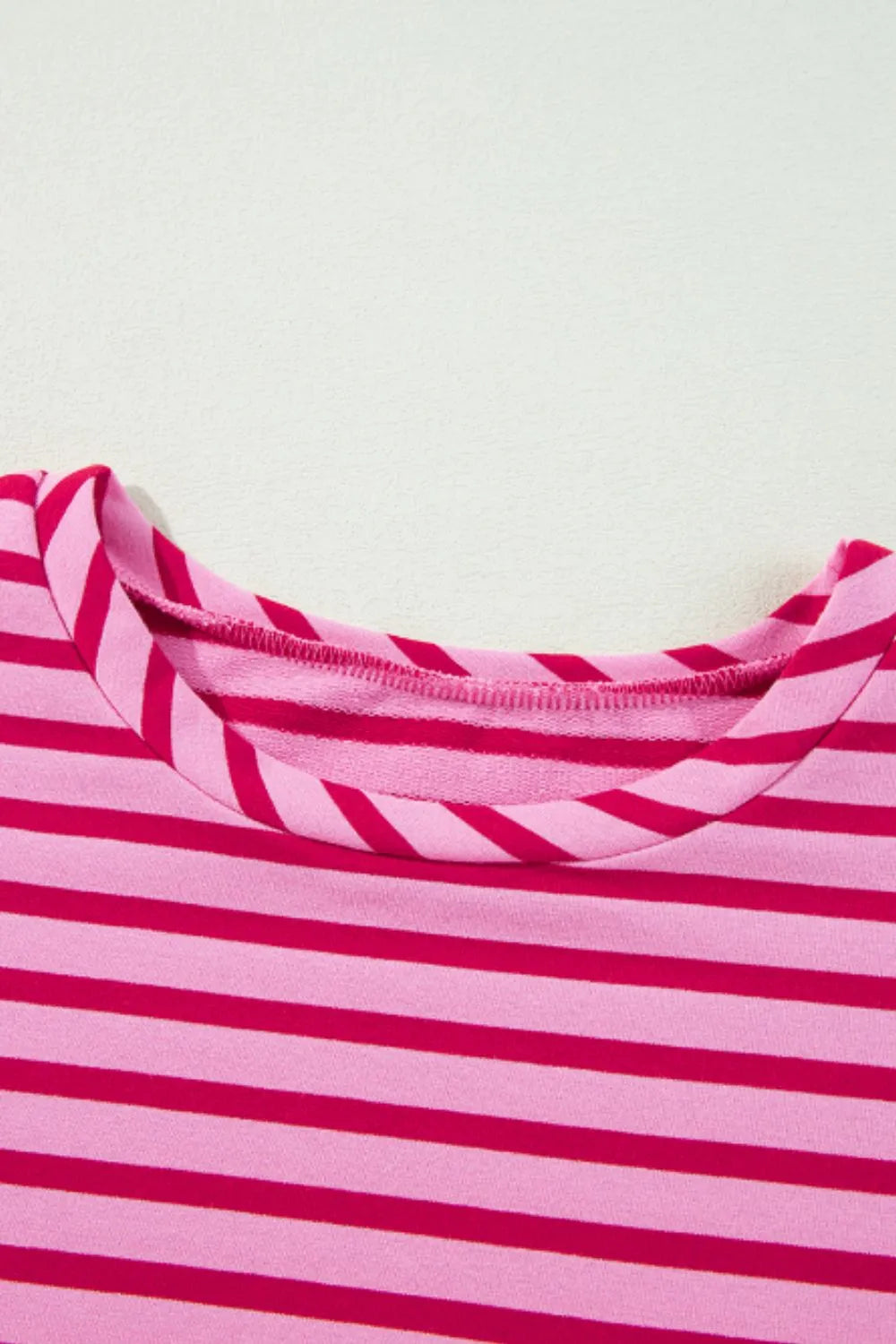 Hot pink and white striped sweatshirt round neck seam and collar binding detail.