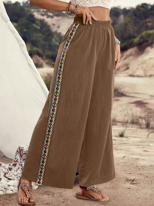 Brown wide-leg pants with elastic waist and embroidered side stripe, flowy drape.