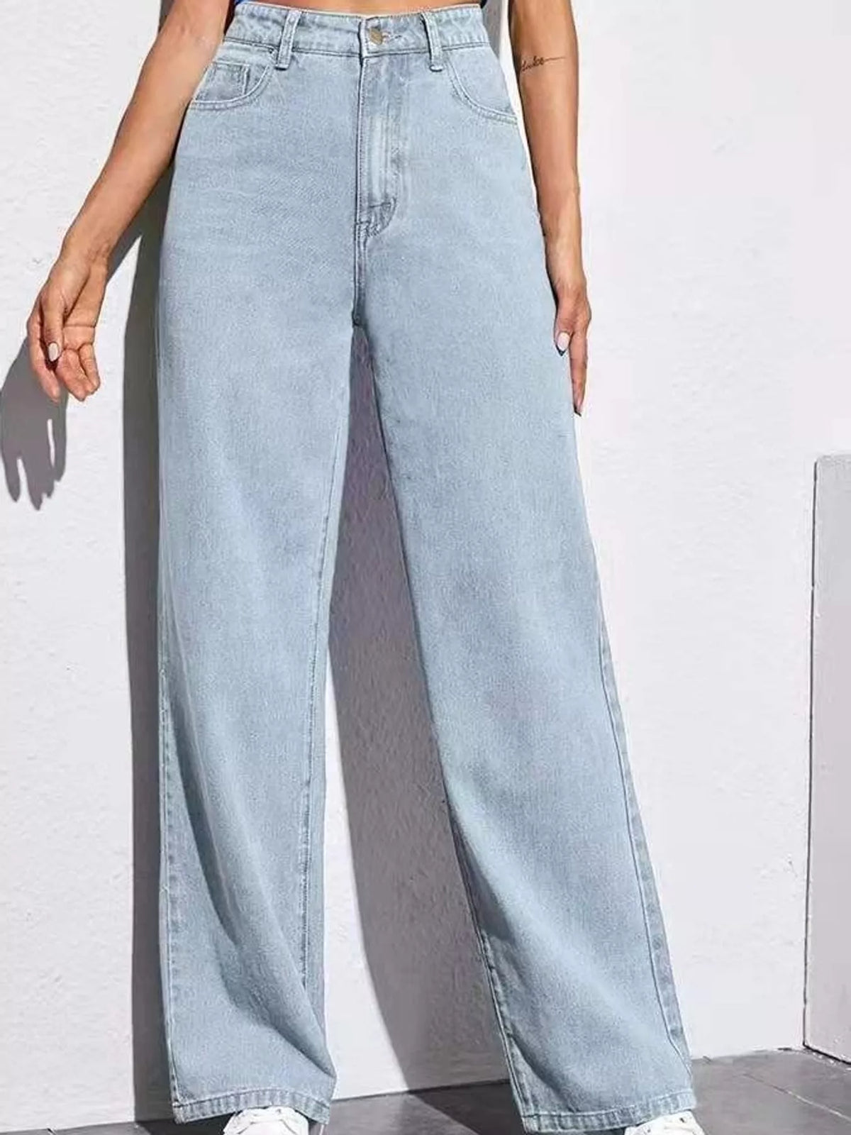 High-waisted wide-leg denim jeans in light blue wash with belt loops and side pockets