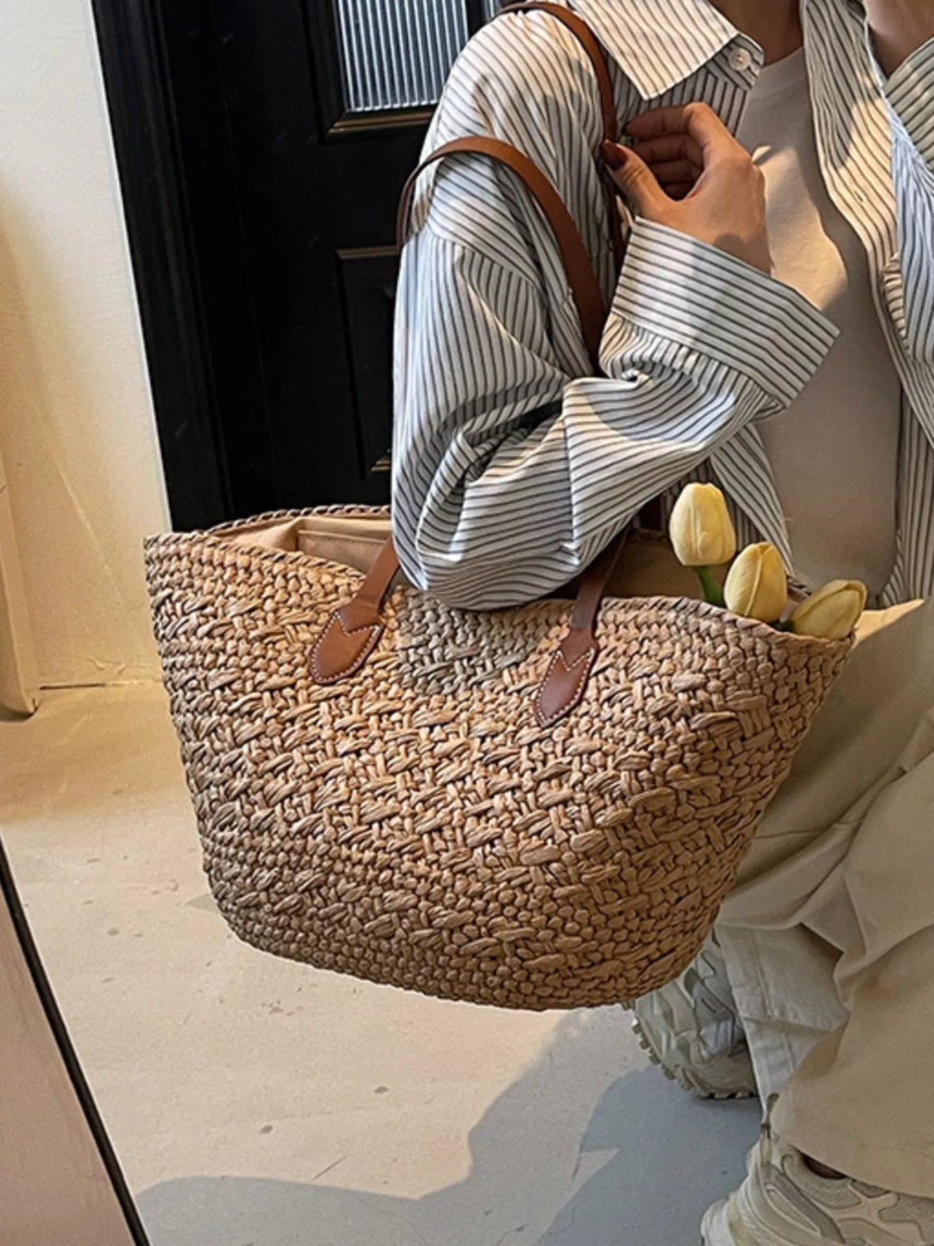 Caramel woven tote shoulder bag with brown leather handles and stitched panels