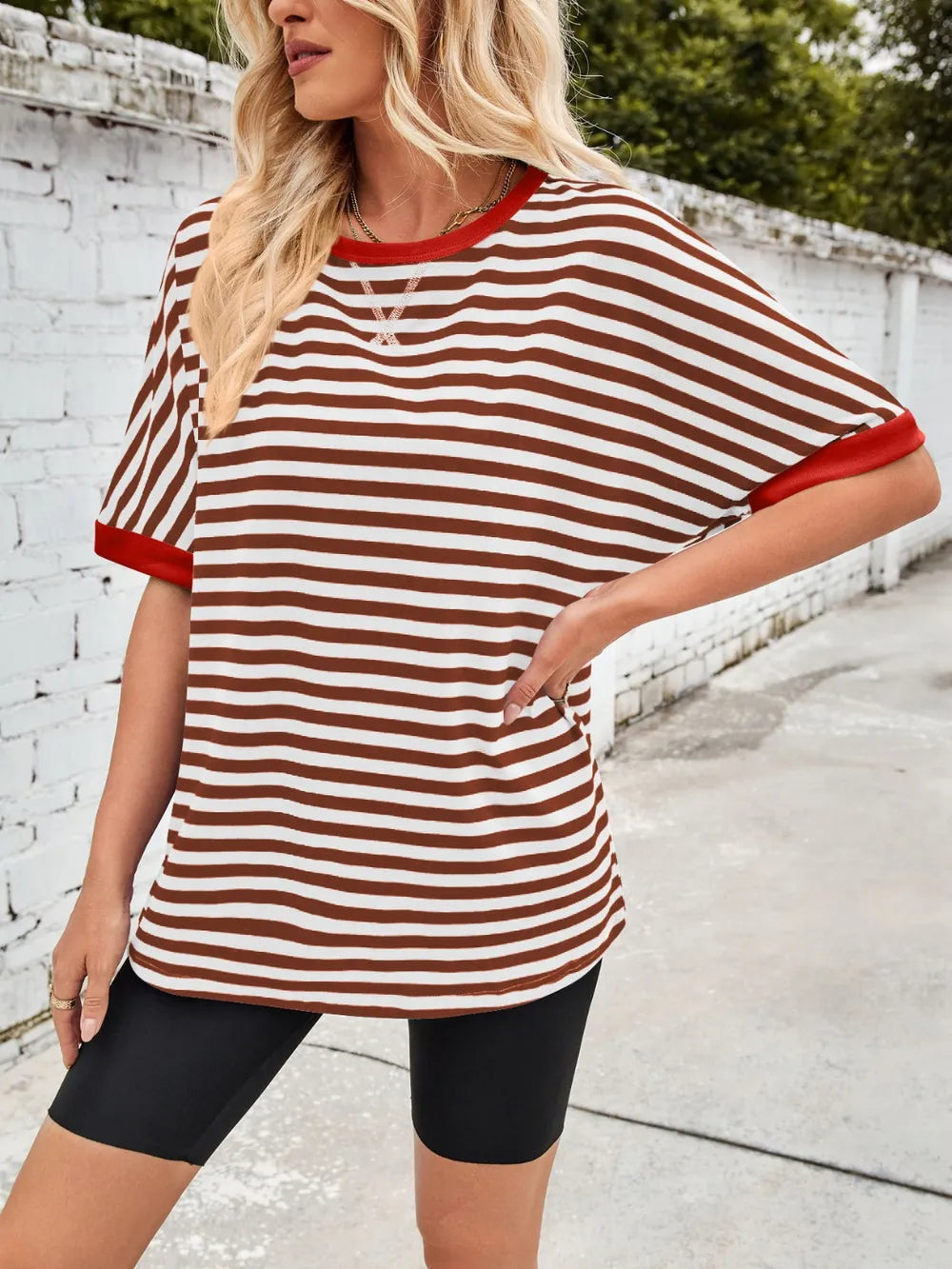 Striped round-neck half-sleeve T-shirt in white with brown stripes and red trim, angled view