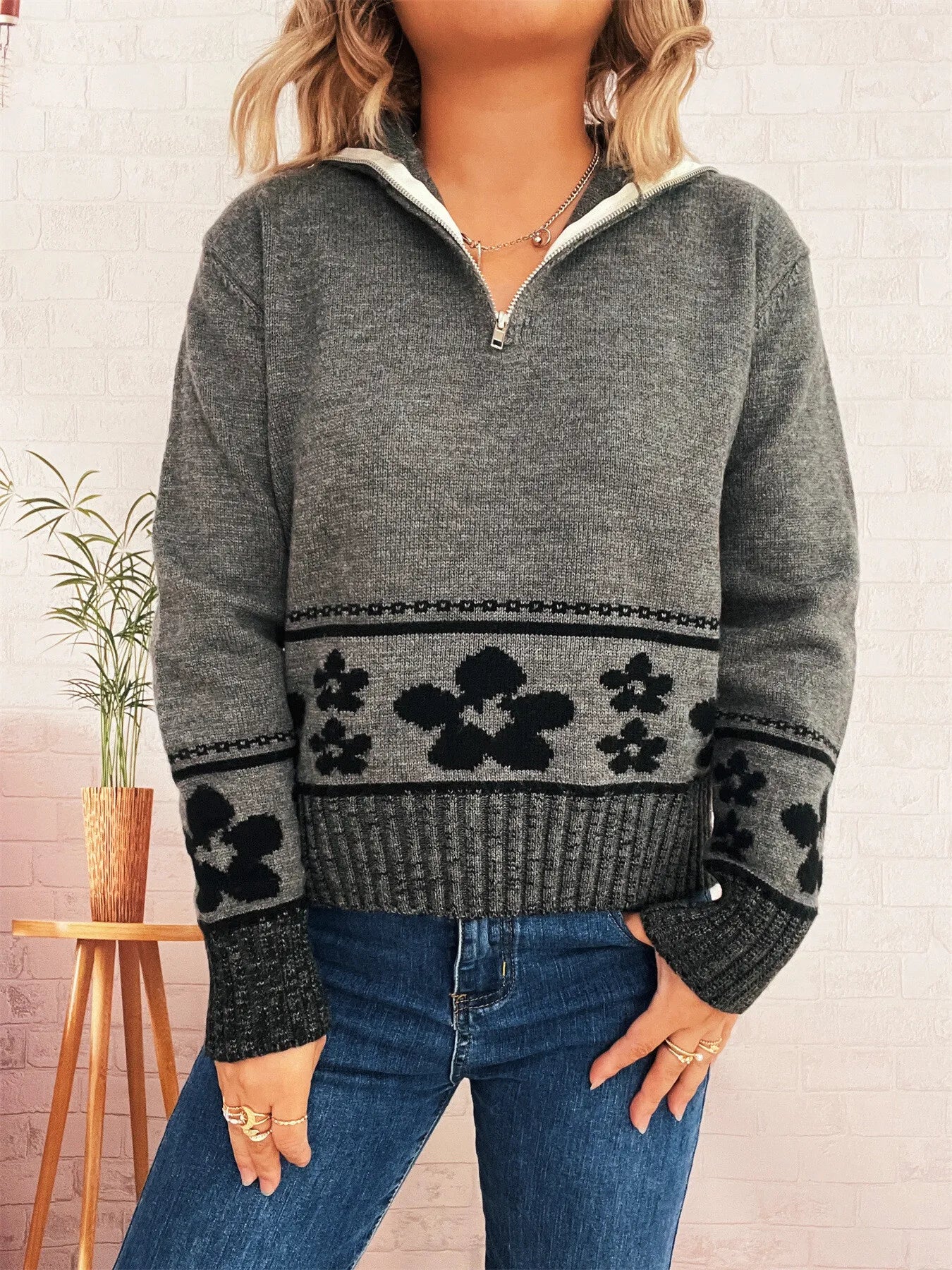 Gray long-sleeve sweater with half-zip collar and black floral panel across chest