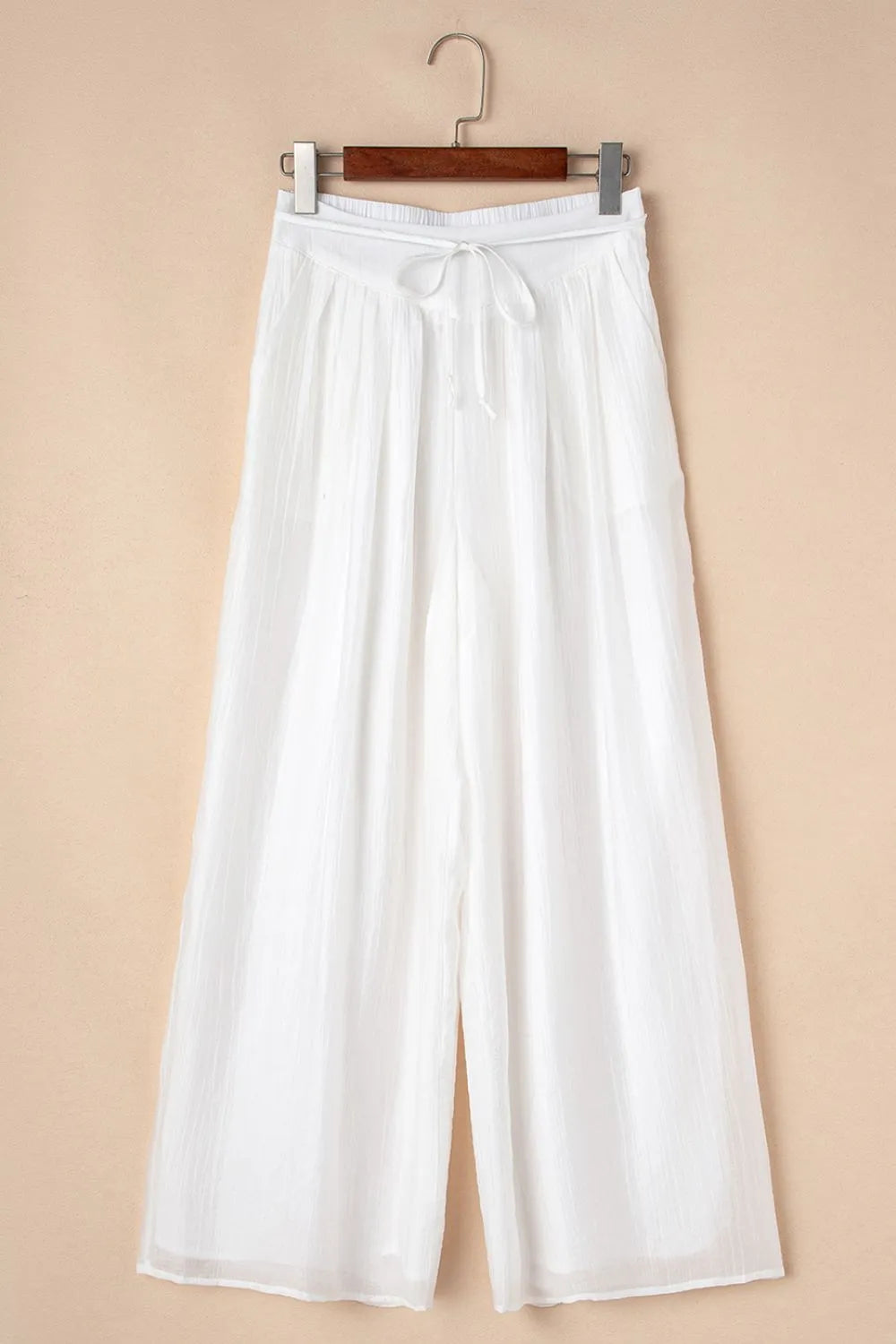 White pleated wide-leg pants with drawstring tie waist and gathered elastic waistband