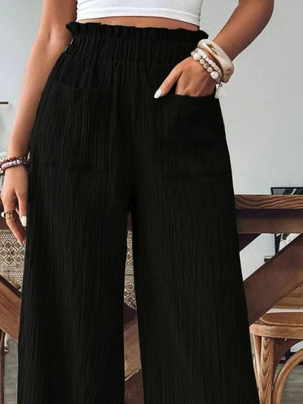 Black pocketed wide-leg pants with elastic waistband, vertical texture detail