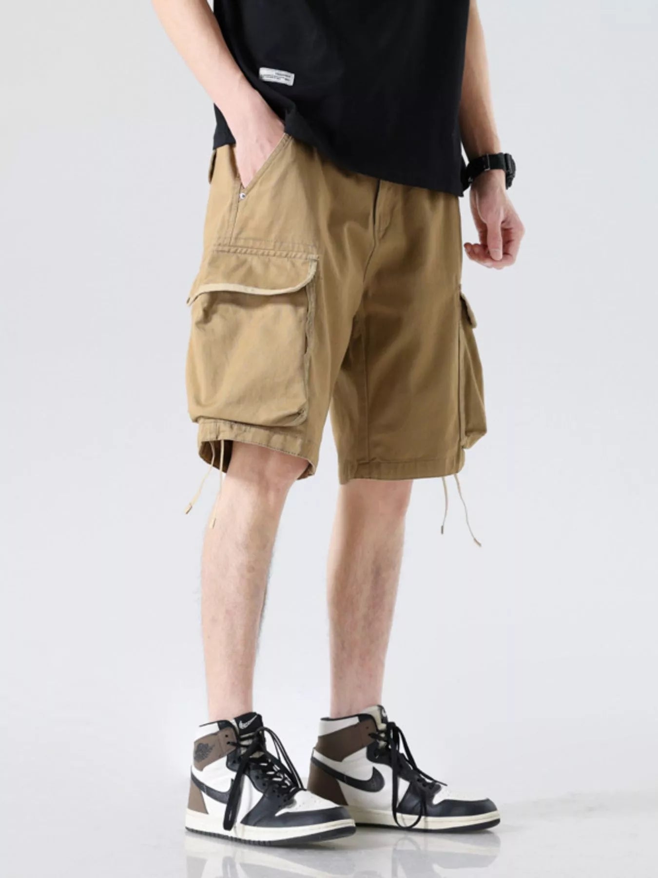 Khaki cargo shorts with side cargo pockets and hanging drawstrings, wide-leg cut