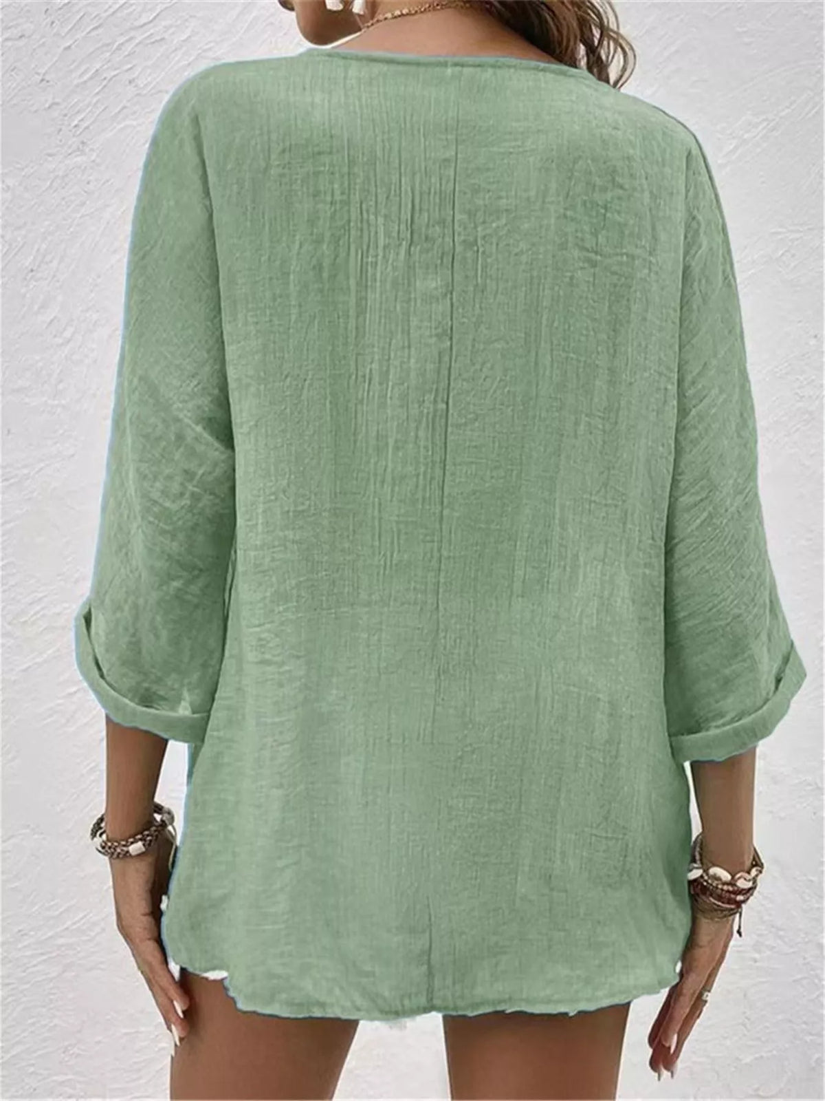 Back view of green V-neck button blouse with 3/4 sleeves and relaxed fit