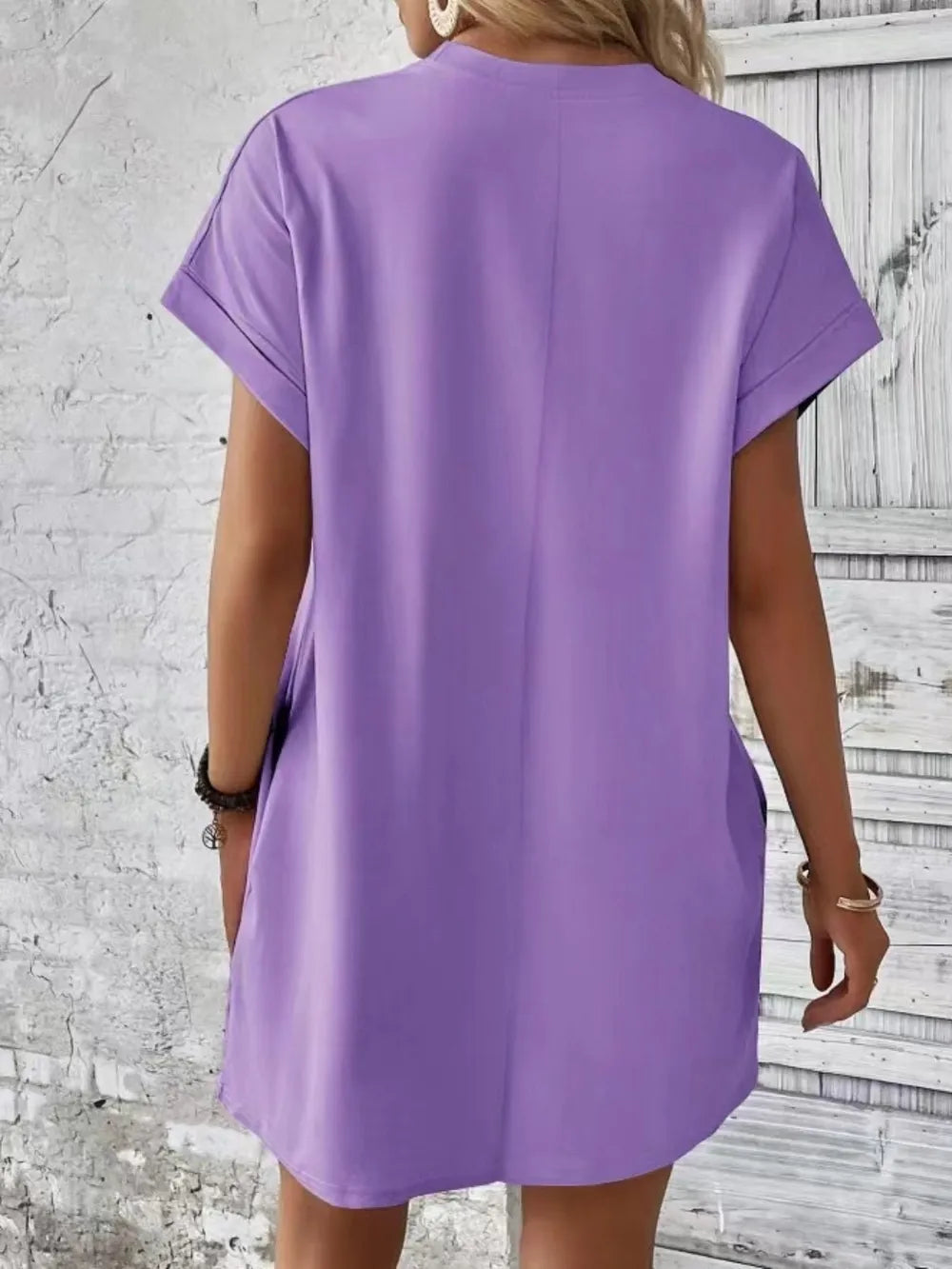 Lavender short-sleeve round-neck tunic dress shown from the back with curved hem
