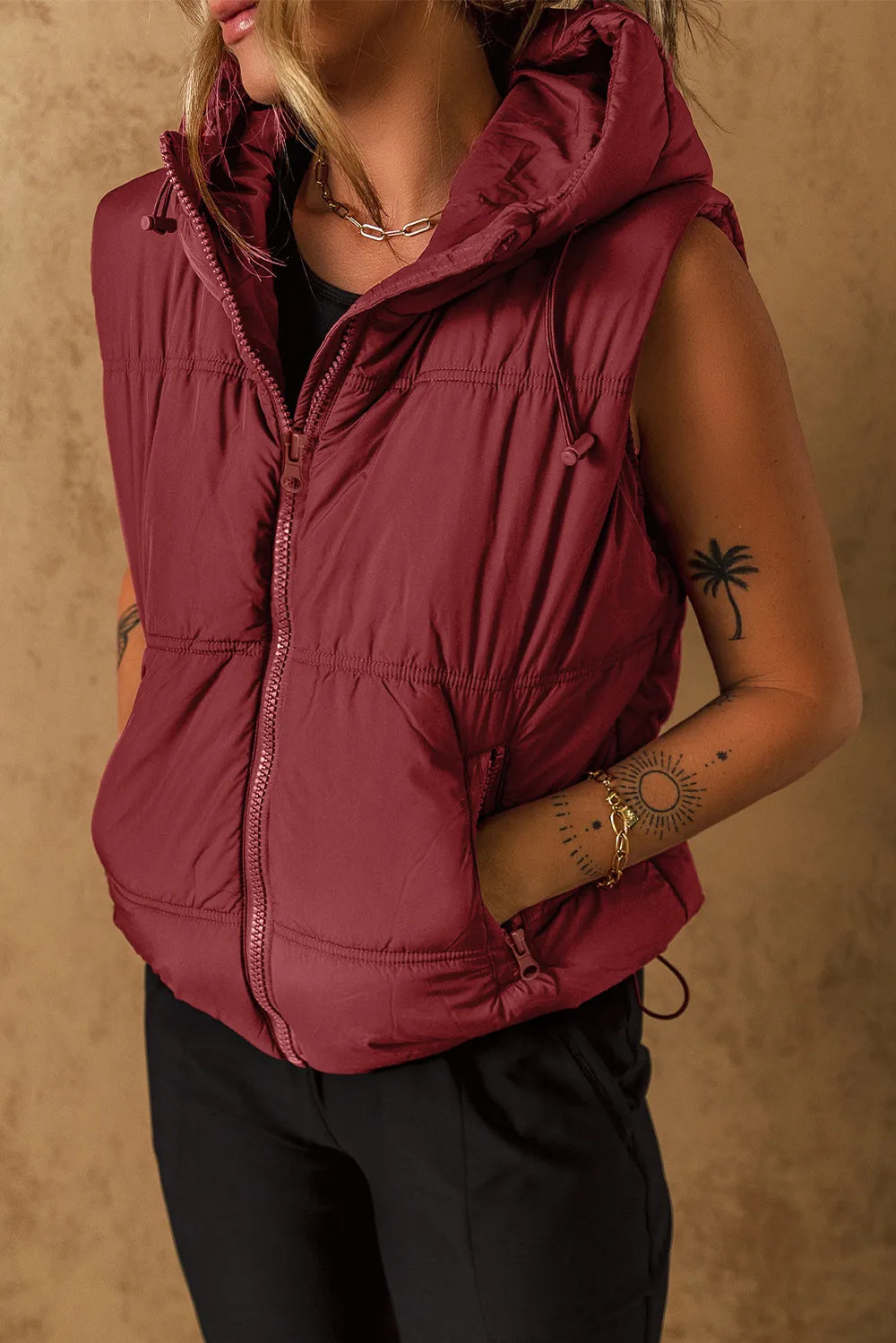 Burgundy hooded zip-up puffer vest coat with quilted front and drawstring waist ties