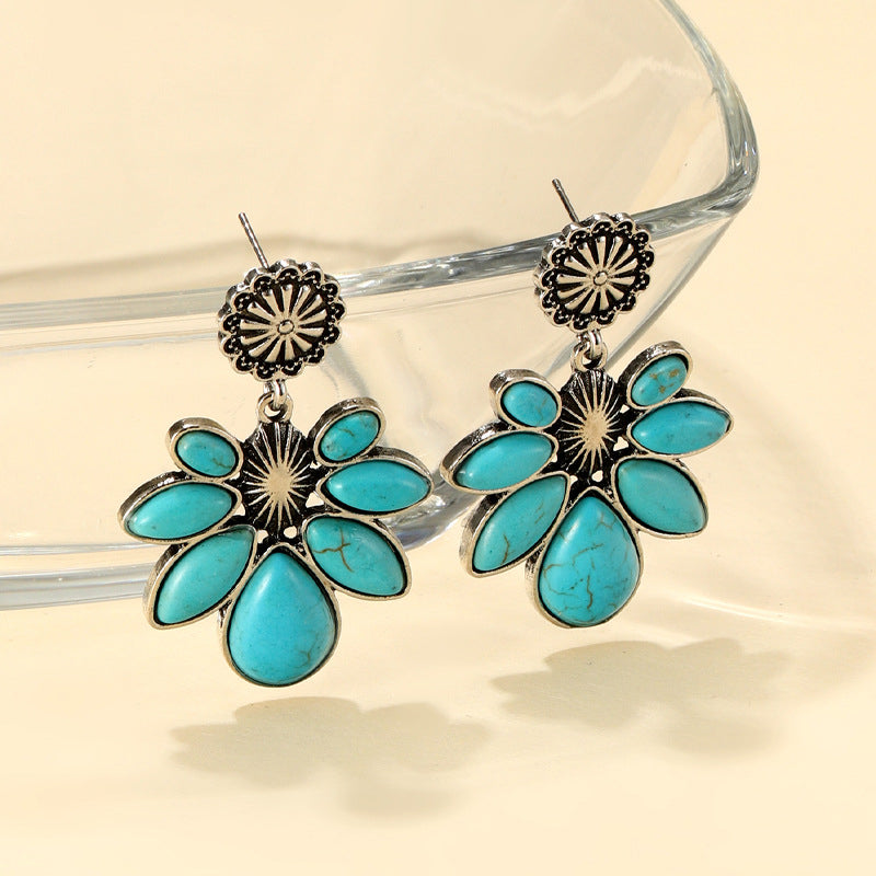 Turquoise flower drop earrings with oval turquoise petals and silver-tone hook backs.