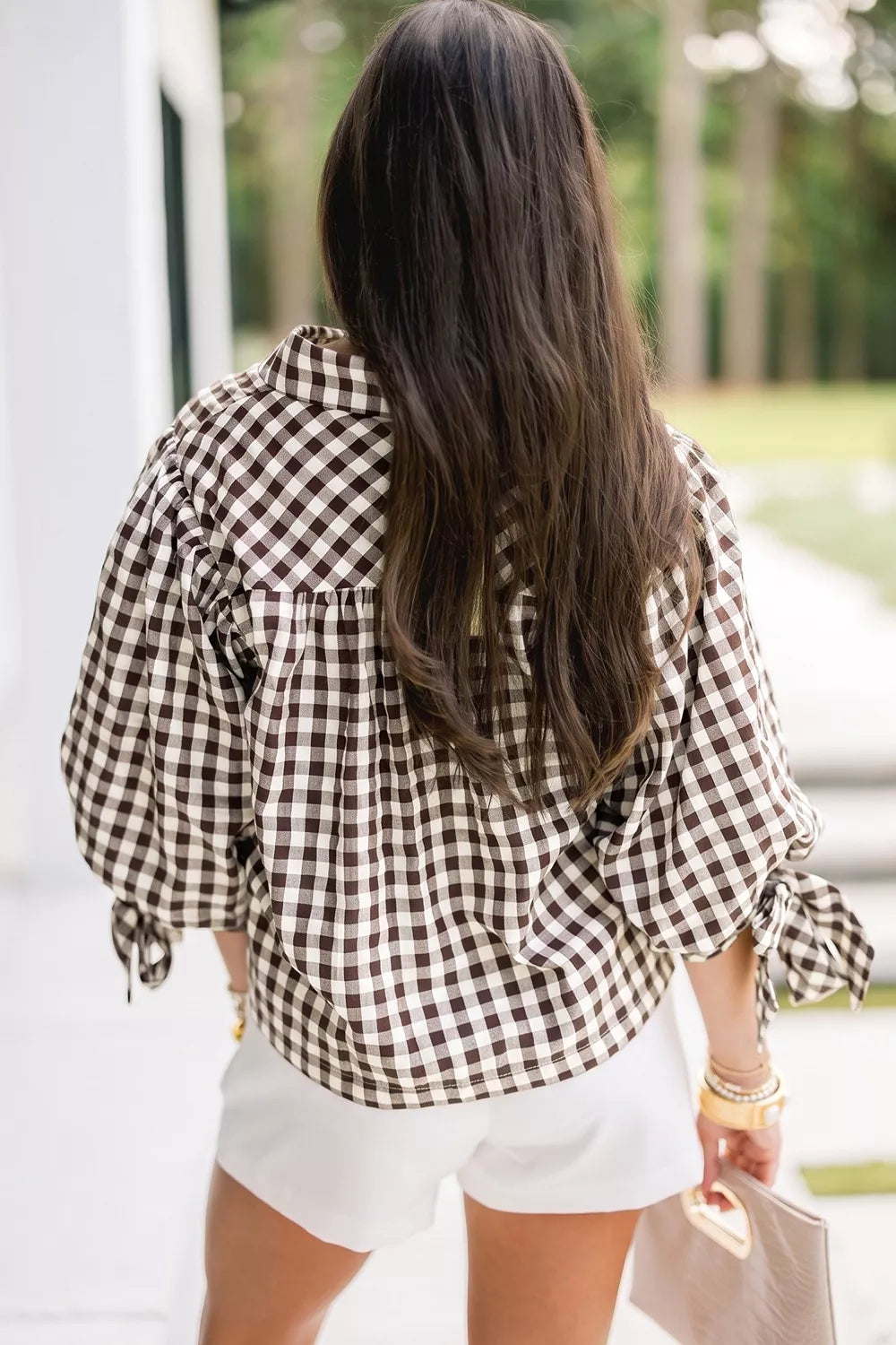 Back view of brown-and-cream gingham tie sleeve button shirt with puff sleeves and scalloped edge