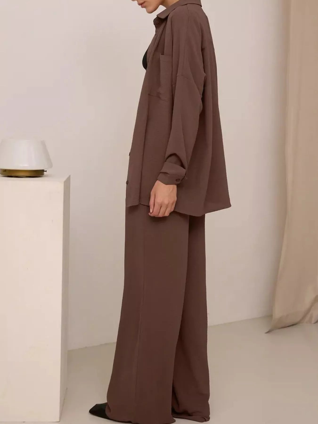 Brown relaxed-fit shirt and wide-leg pants set, side view of loose shirt and flared legs