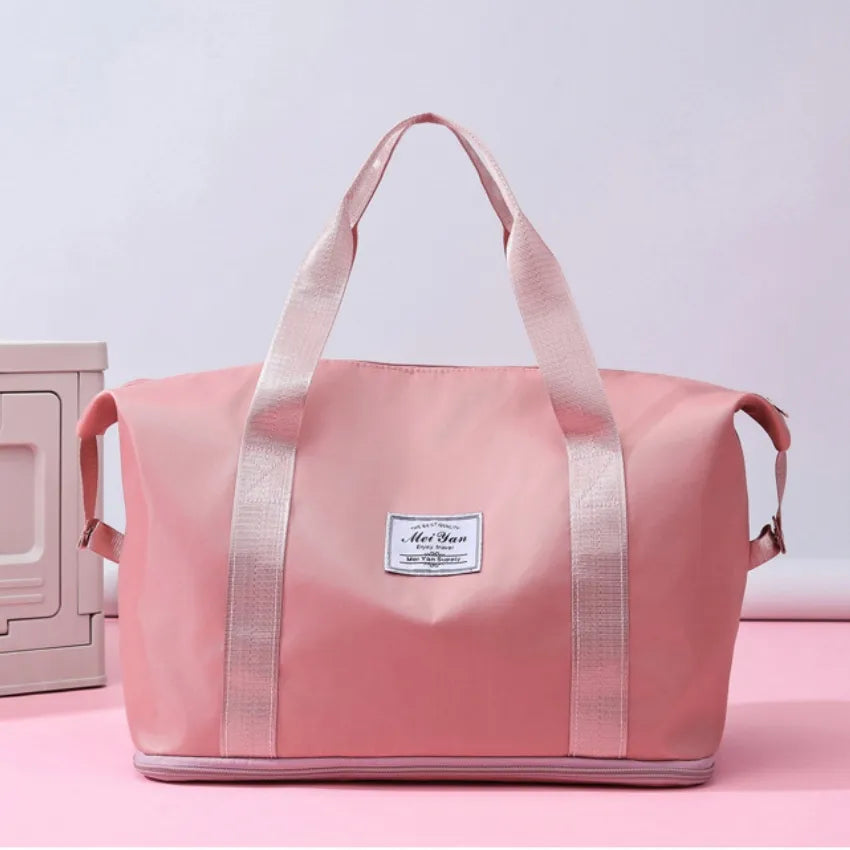 Dusty pink large duffle bag with long handles and front patch label
