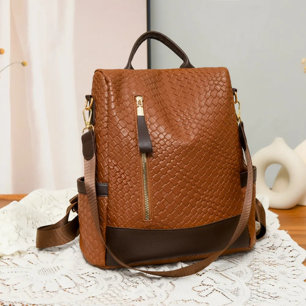 Vegan leather backpack bag in brown with braided texture, top handle, and front zipper.