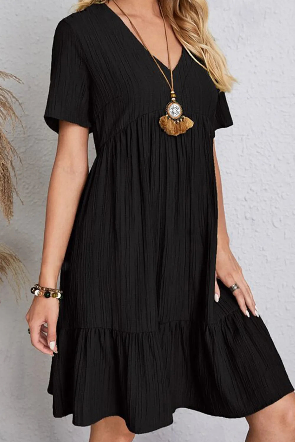 Back view black ruched V-neck short-sleeve tiered dress with gathered waist