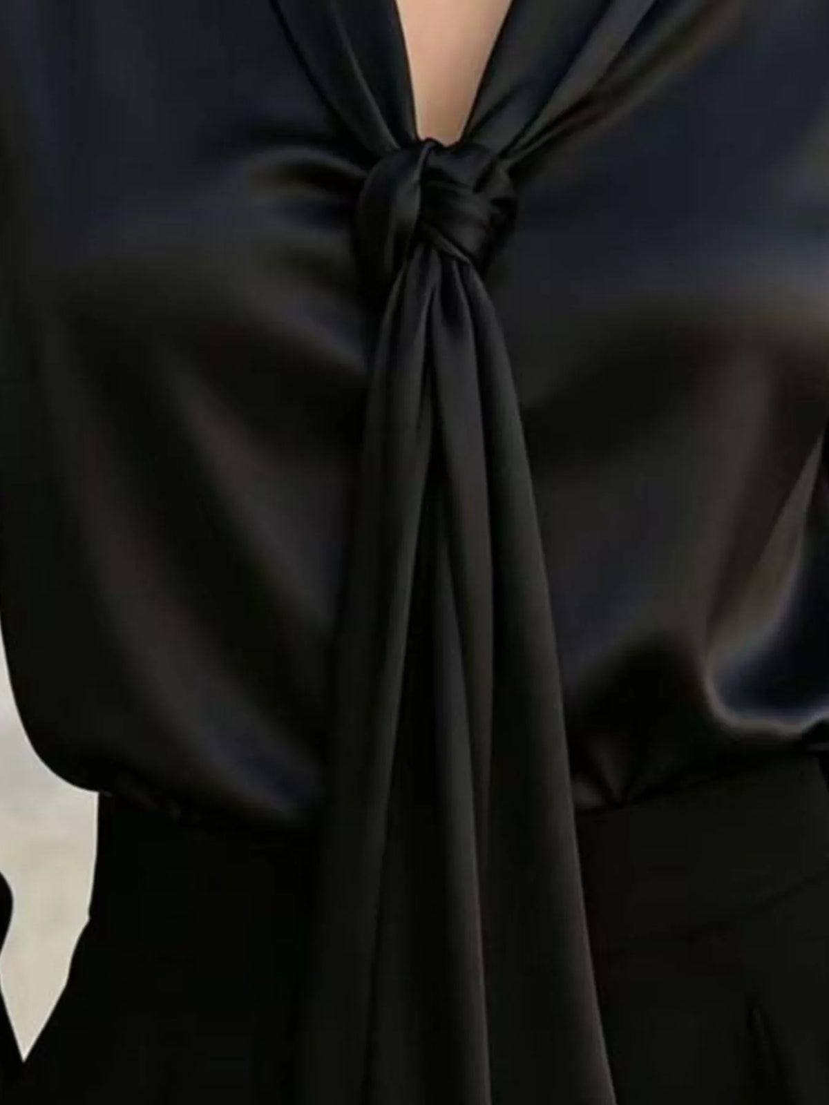 Black satin blouse front bow tie detail at neckline