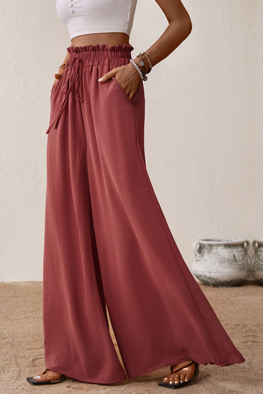 Deep red wide-leg pants with smocked waist and gathered paperbag front