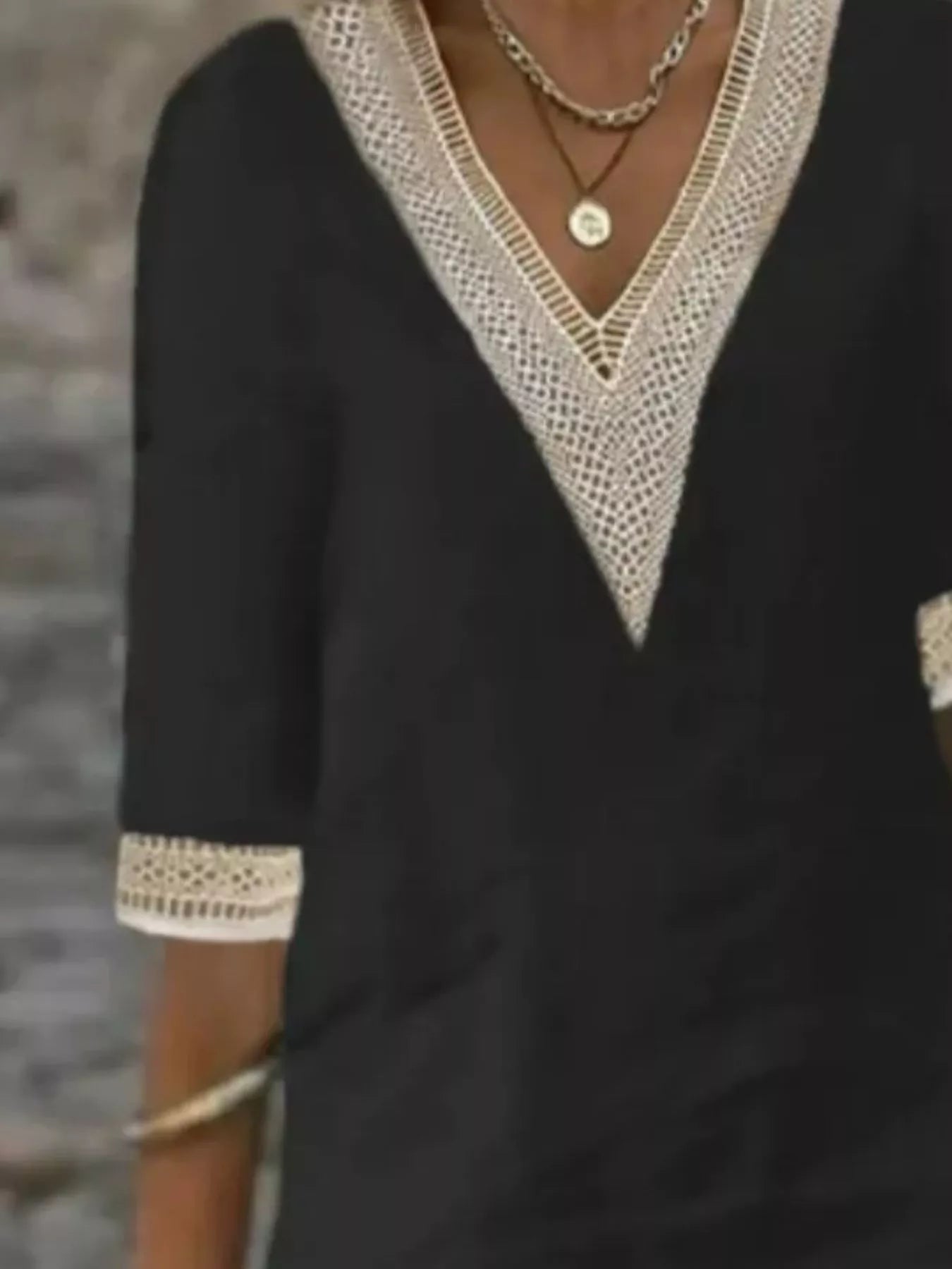 Black V-neck lace-trim dress close-up with textured lace neckline and half sleeves