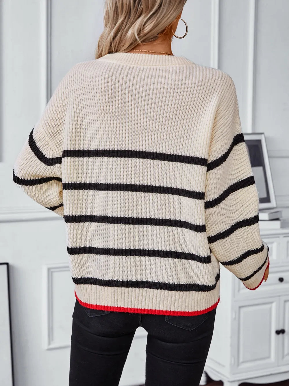 Cream knit sweater with black stripe bands, crew neck, dropped shoulders, red cuff trim