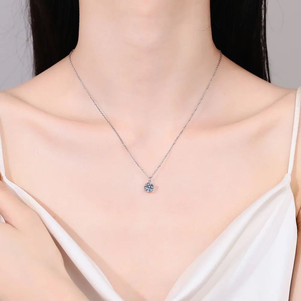 Sterling silver necklace with round moissanite pendant centered at the neck