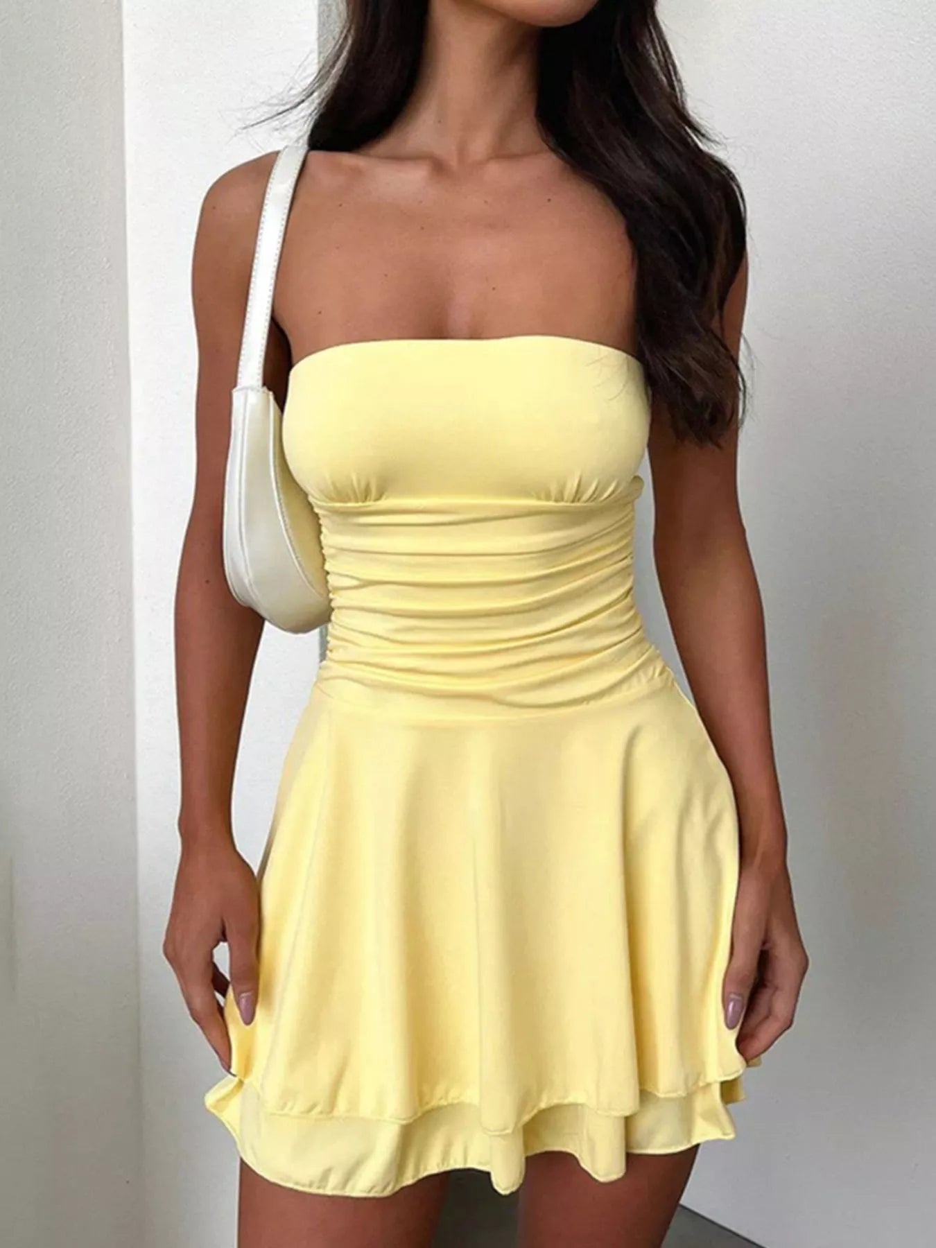 Pastel yellow strapless ruched mini dress with fitted bodice and flared skirt