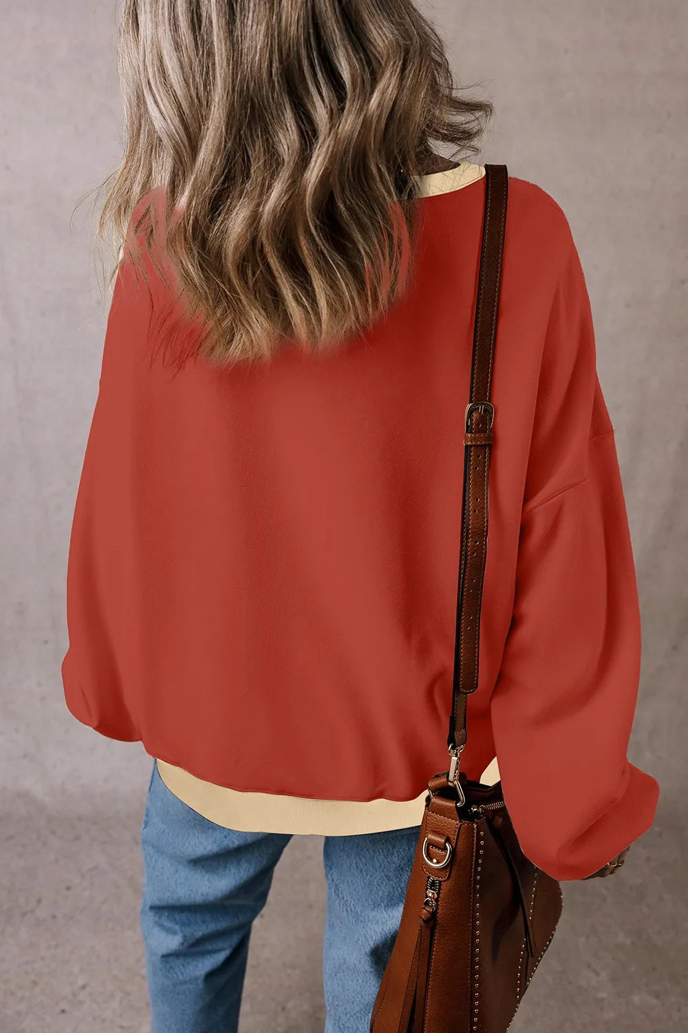Rust red long-sleeve sweatshirt with ribbed light hem and contrast V yoke