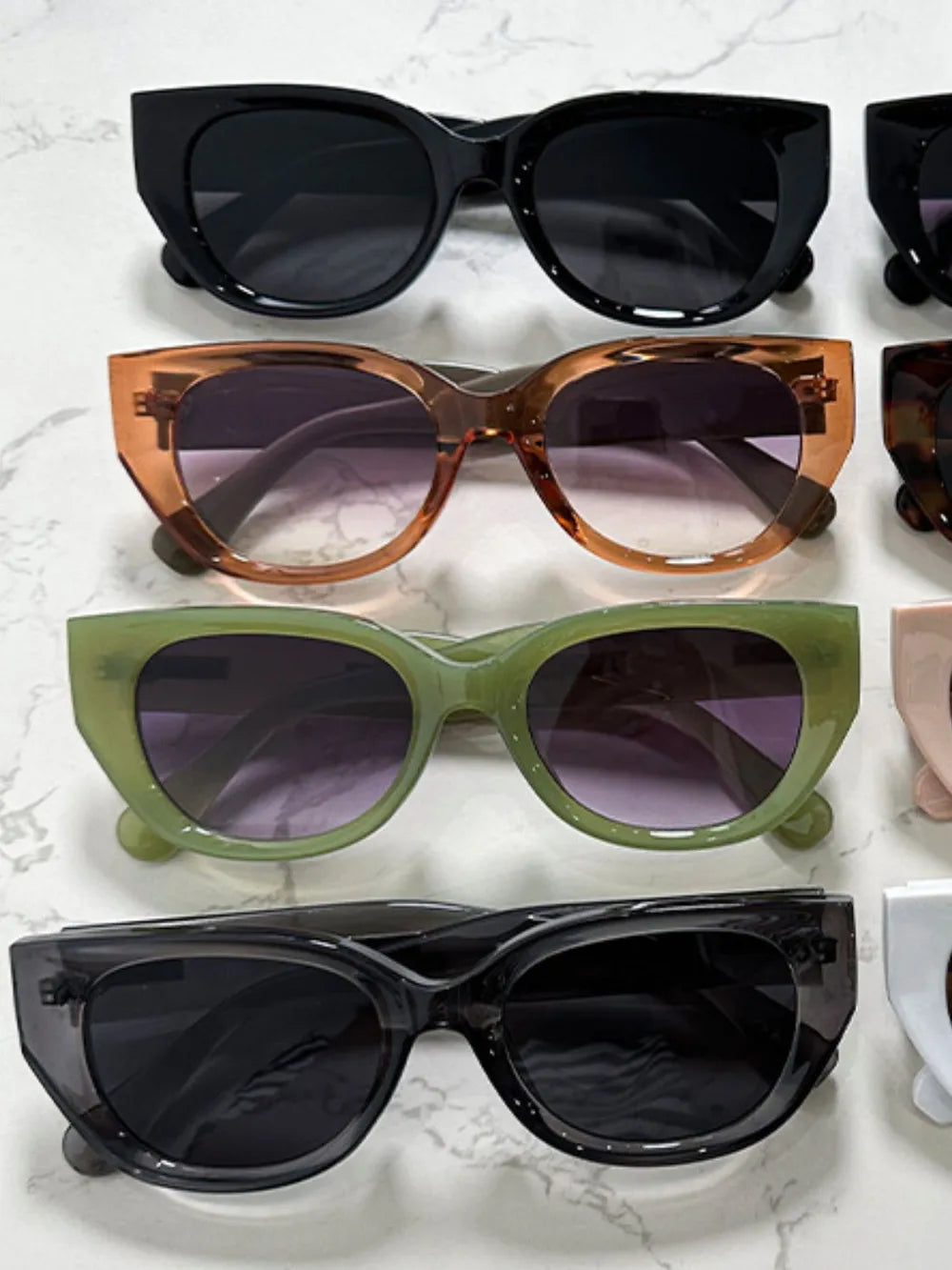 Assorted cat-eye polycarbonate sunglasses in black, brown, and green frames