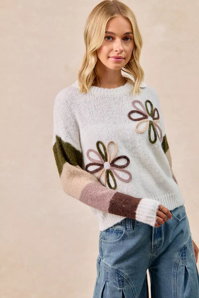 Ivory flower color block sweater with floral appliques and striped sleeve bands, front view