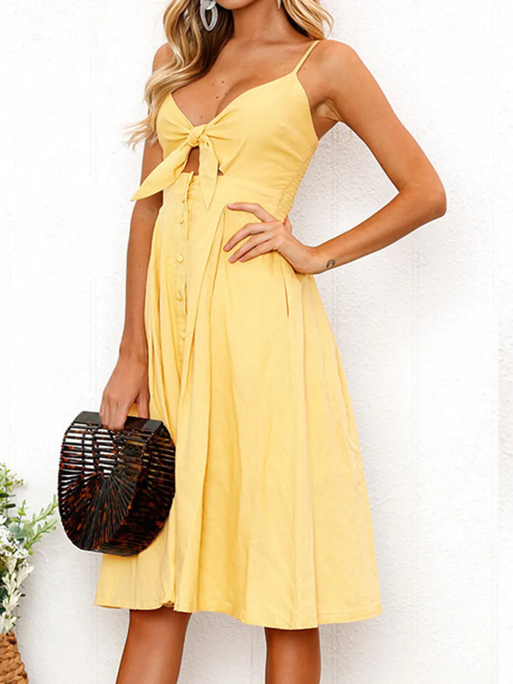 Yellow cami dress with bow at neckline, button front, gathered skirt and thin straps