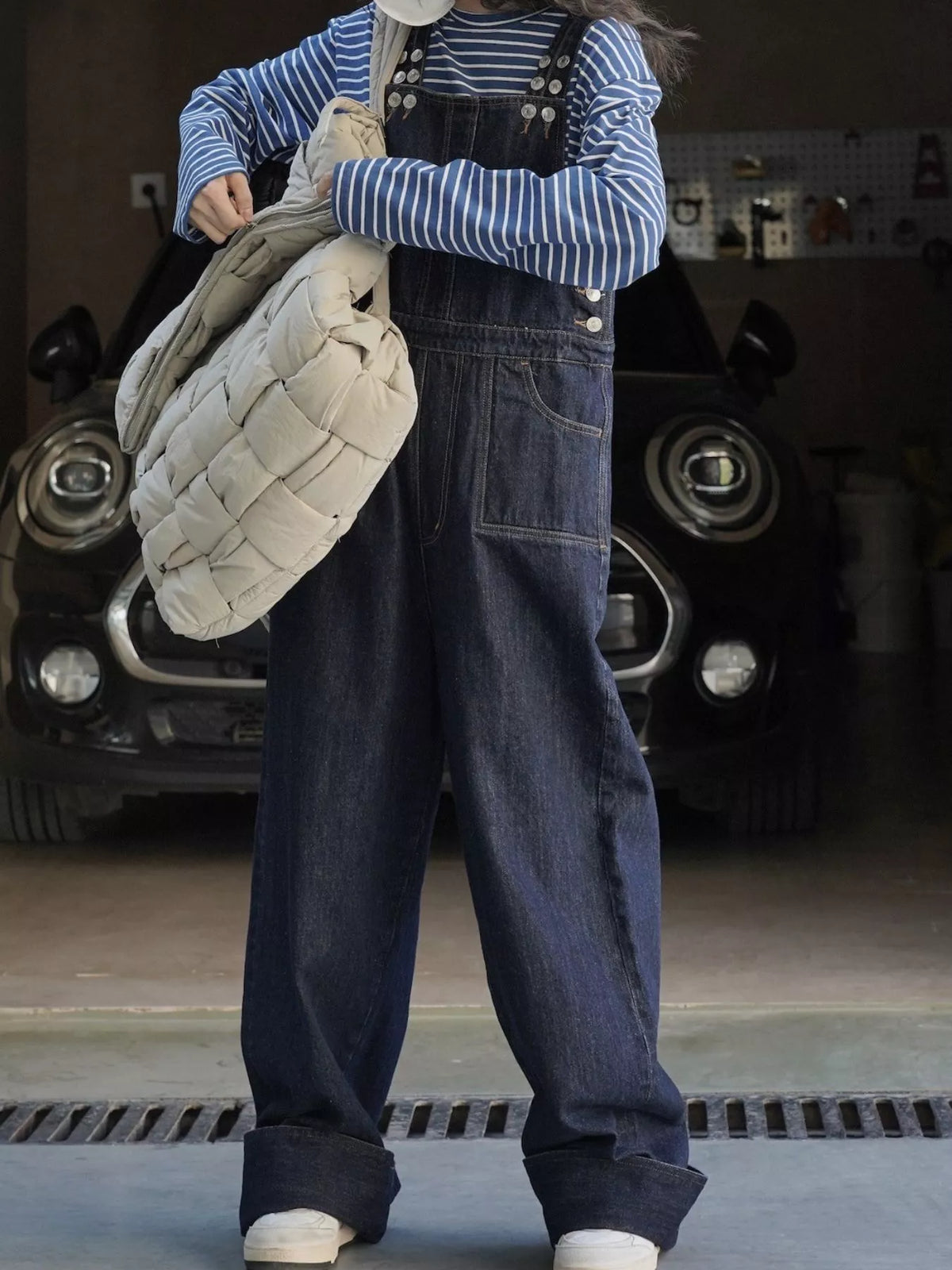 Dark-wash denim overalls with multiple front buttons, bib pocket, and baggy legs