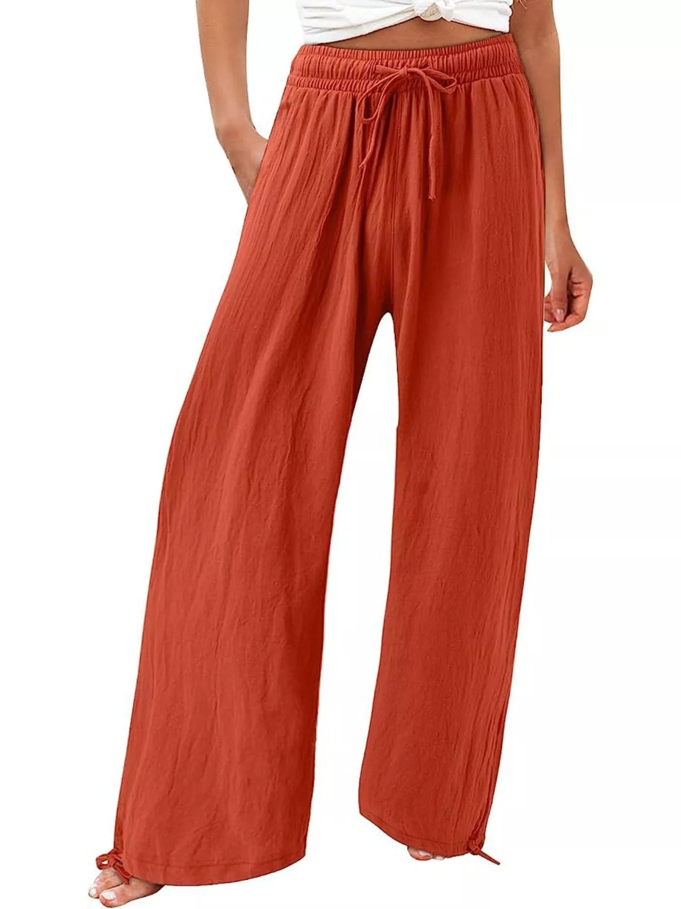 Rust red wide-leg pants with drawstring waist and loose, draped fit