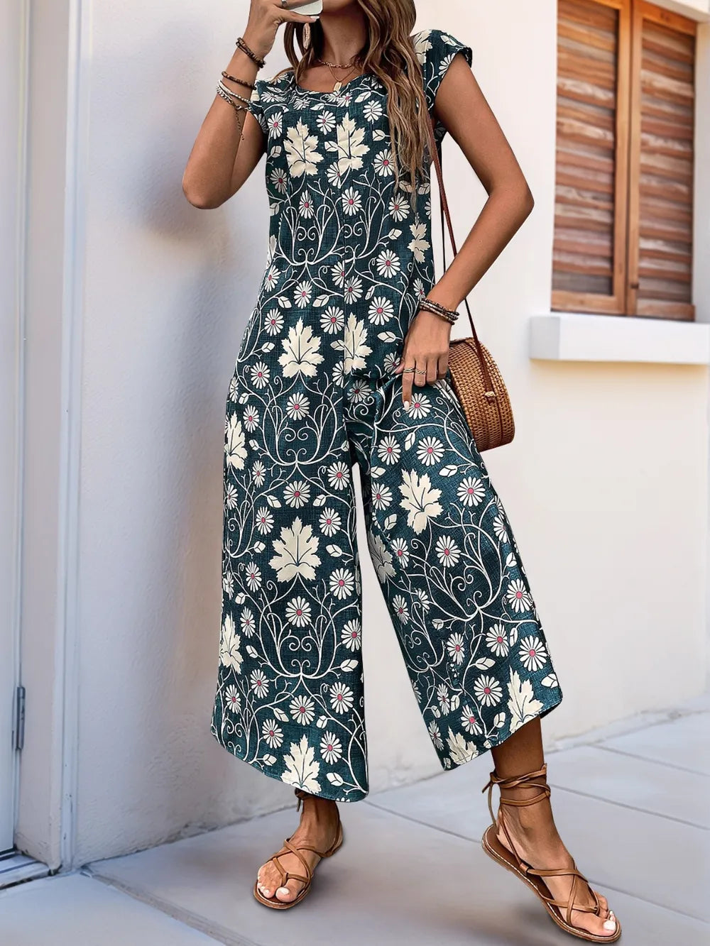 Dark teal printed wide-leg jumpsuit with round neckline and wide, draped legs