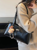 Black vegan leather medium shoulder bag with top handles and dangling teddy charm