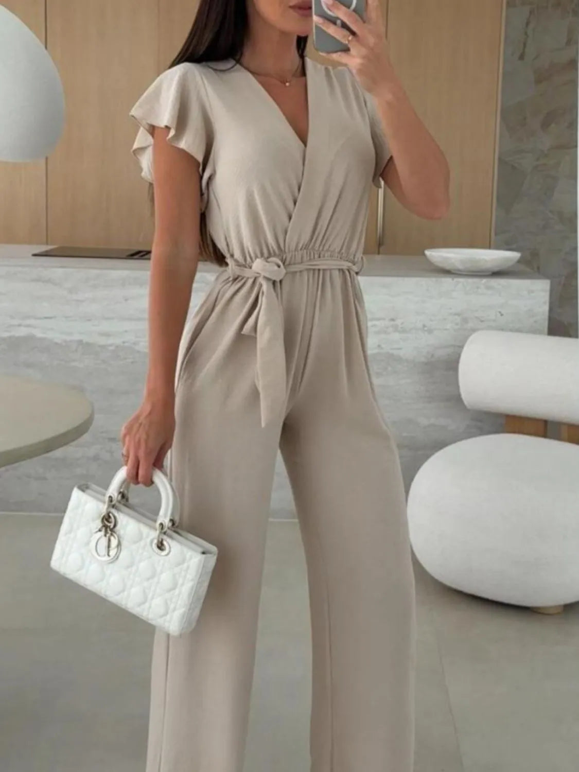 Tan tied ruffled wide-leg jumpsuit with flutter sleeves and V-neck