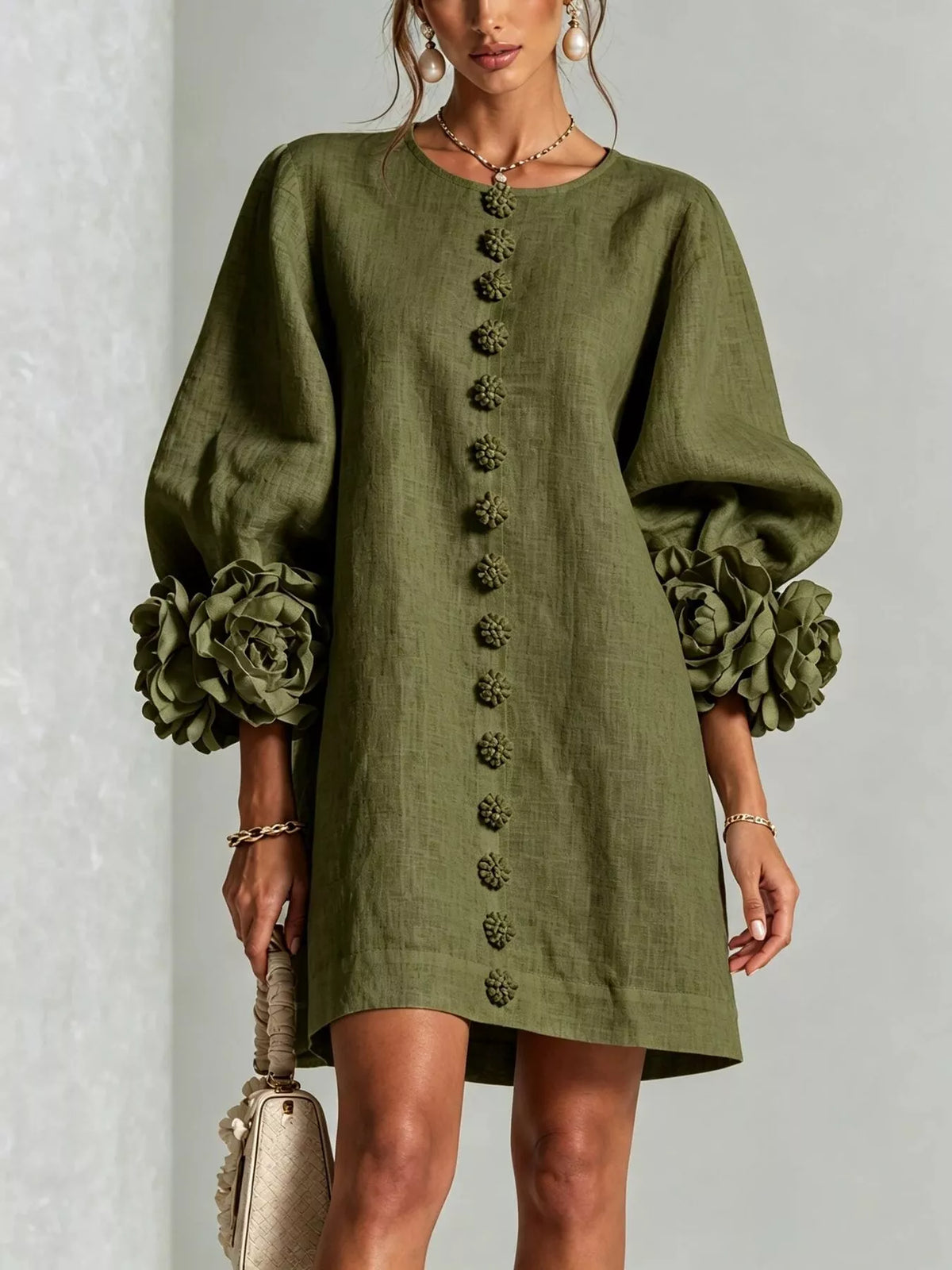 Army green mini dress with round neck, vertical button trim, and 3D floral sleeve cuffs.