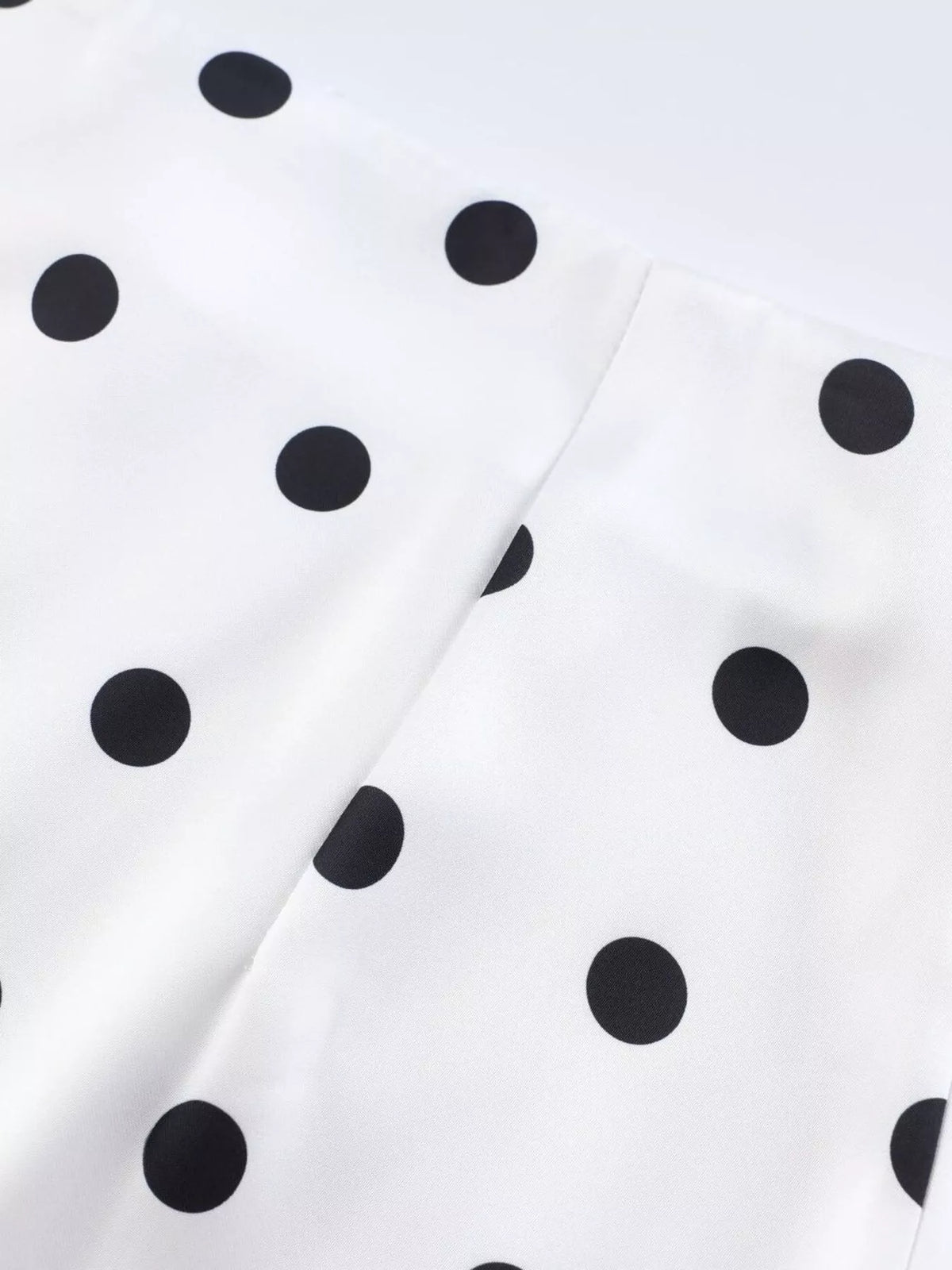 White polka dot skirt with stitched panels and curved seam