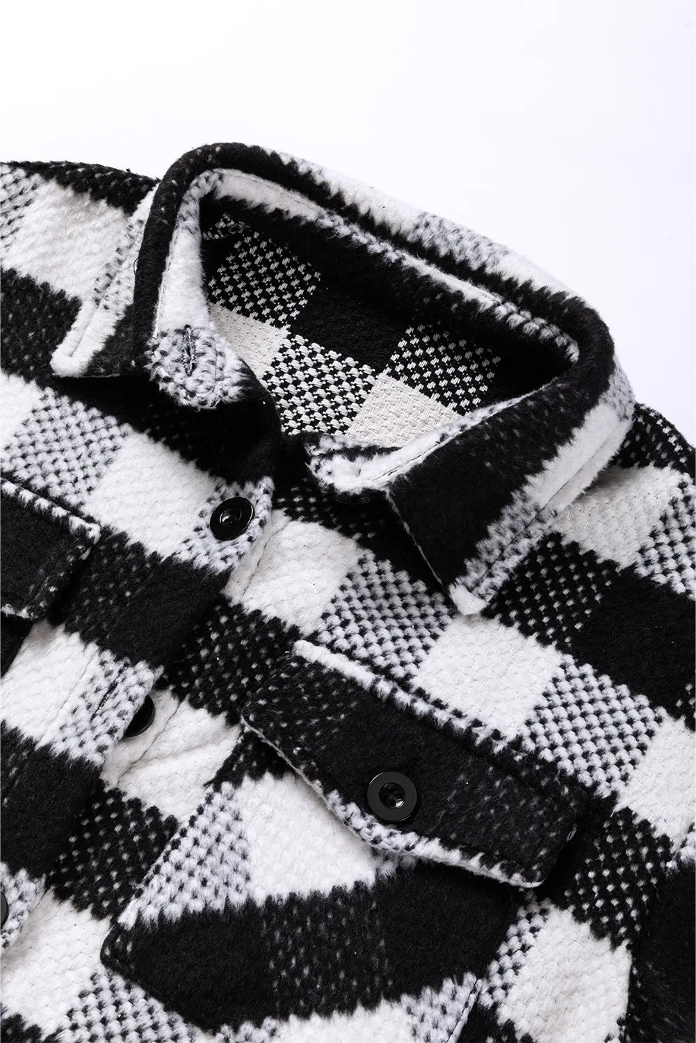 Black-and-white plaid jacket placket with front buttons and spread collar detail
