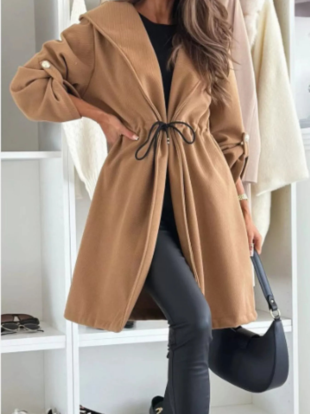 Light brown hooded jacket with oversized sleeves and black drawstring waist, front buttons