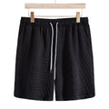 Men's black lightweight drawstring shorts with elastic waistband and textured scale pattern