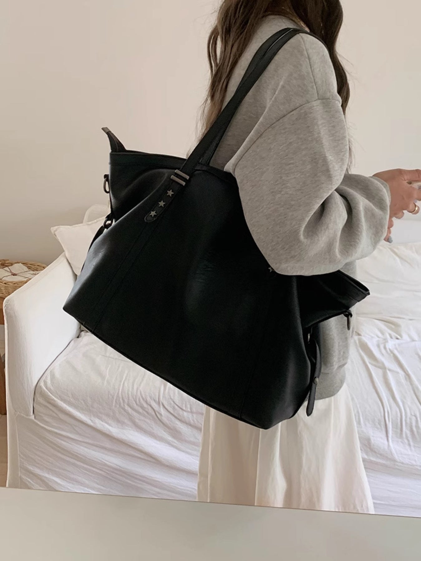 Star-embellished PU shoulder bag, large black, carried on the shoulder.