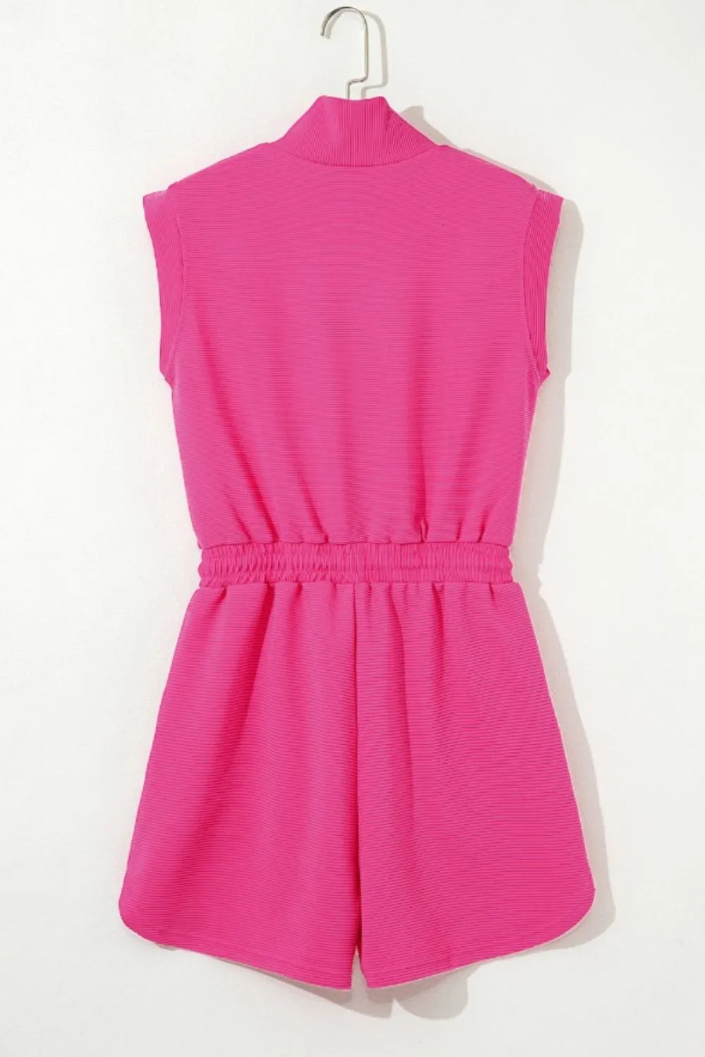 Hot pink textured romper on hanger, back view with high collar and elastic waist